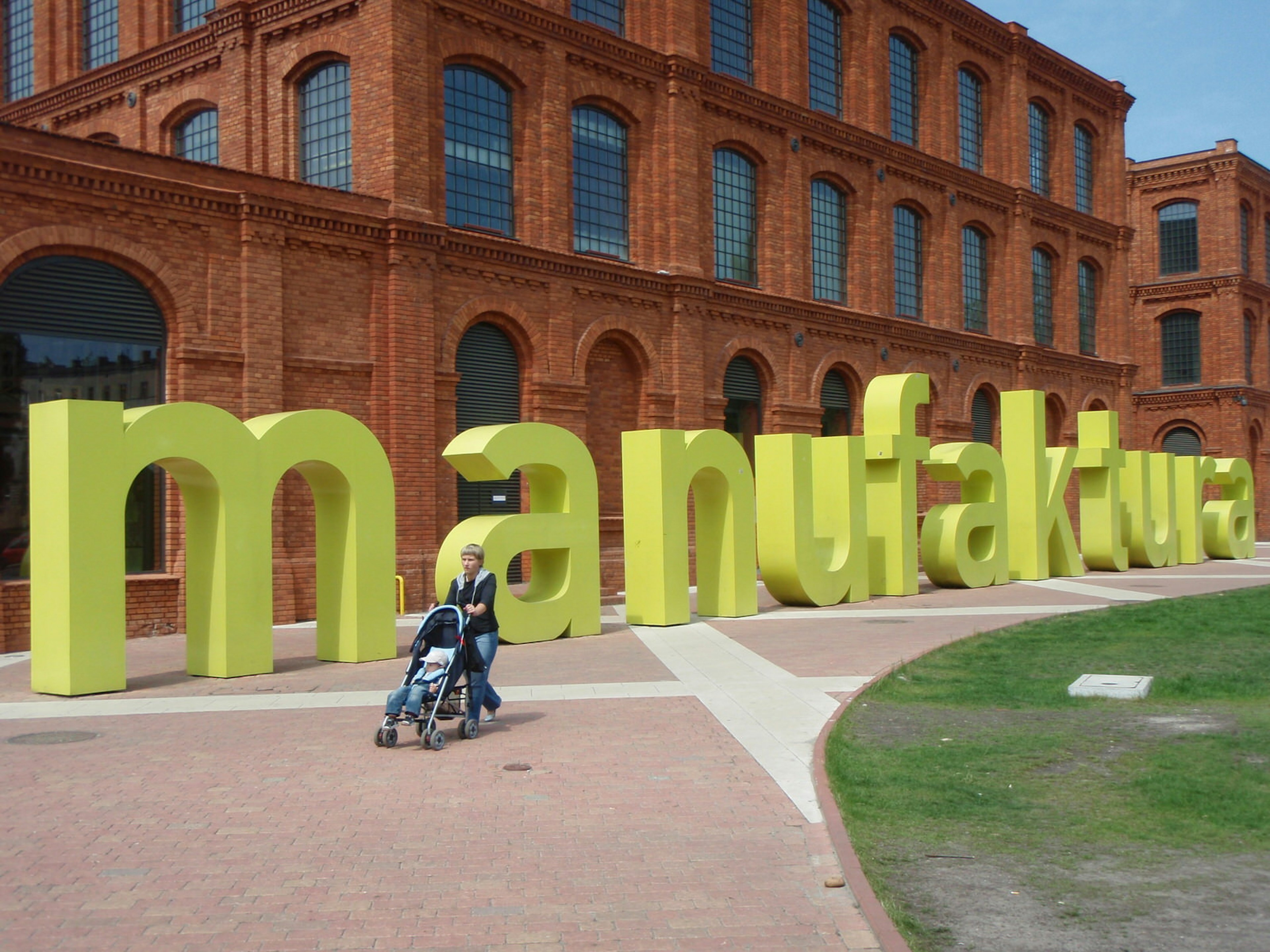 Massive yellow artwork spelling out 'Manufaktura', the name of this factory turned shopping complex © Tim Richards / Lonely Planet