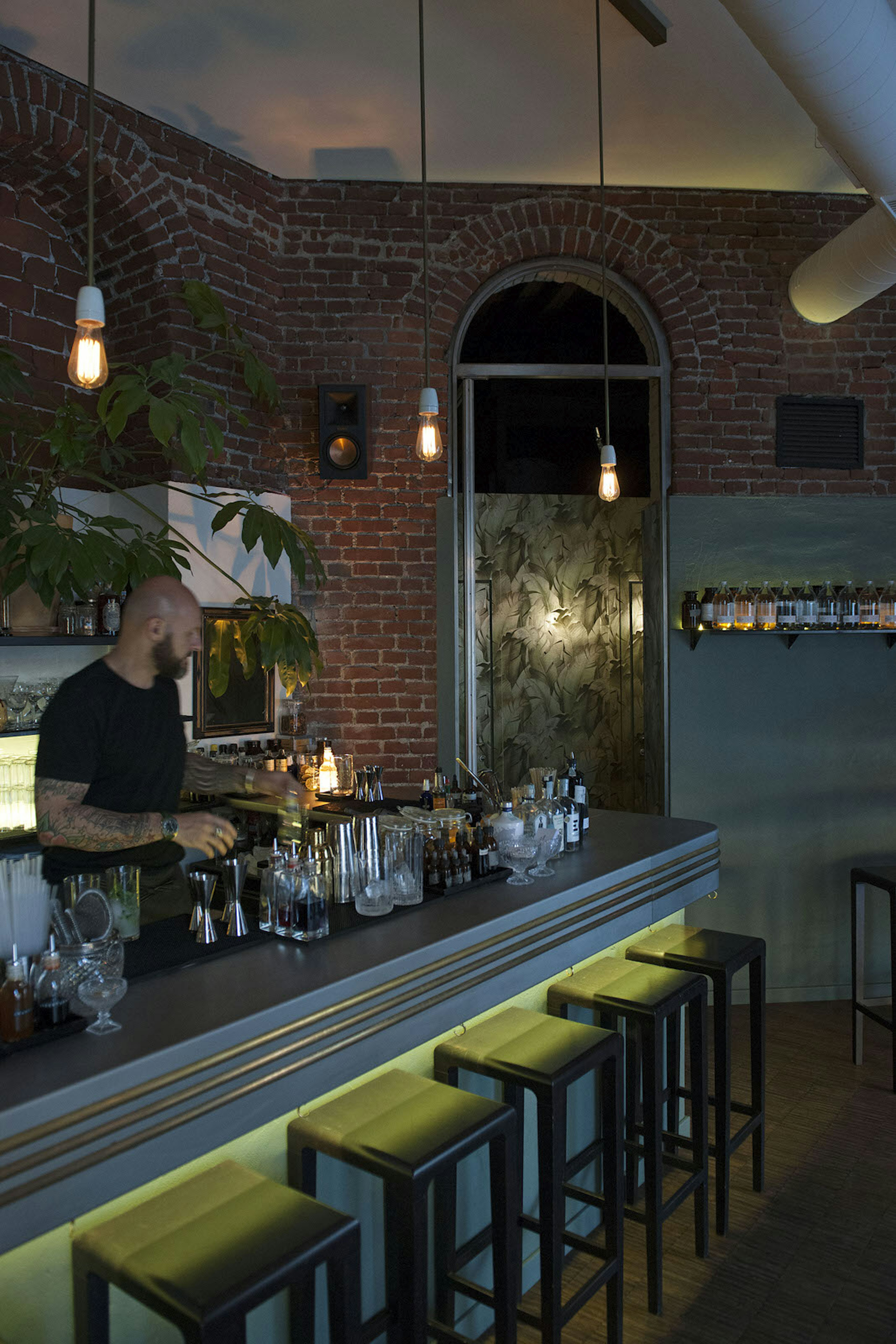 A bartender behind the bar at at Milan's Botanical Club cocktail bar
