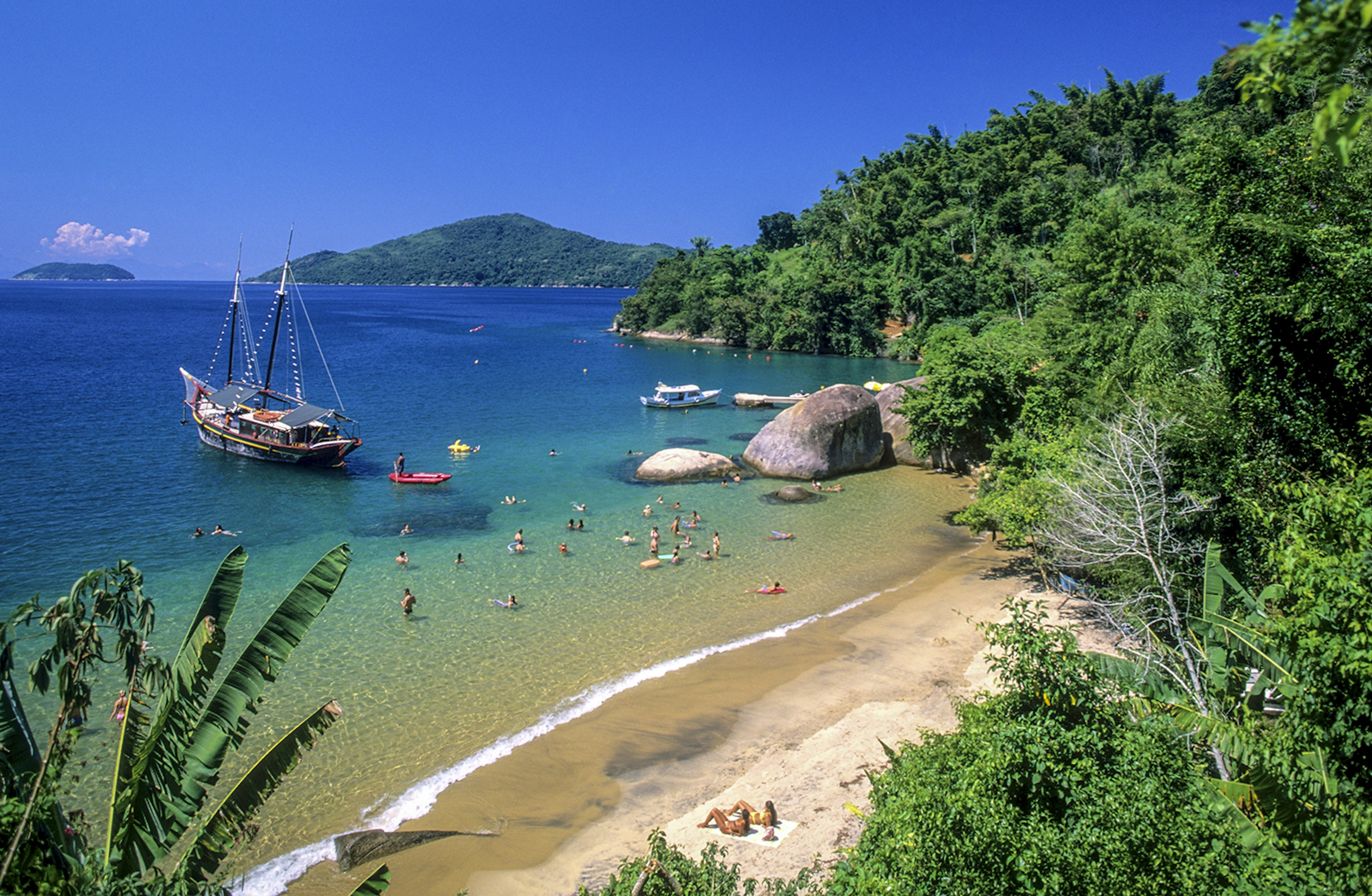 Sun-drenched beach with a boat offshore.