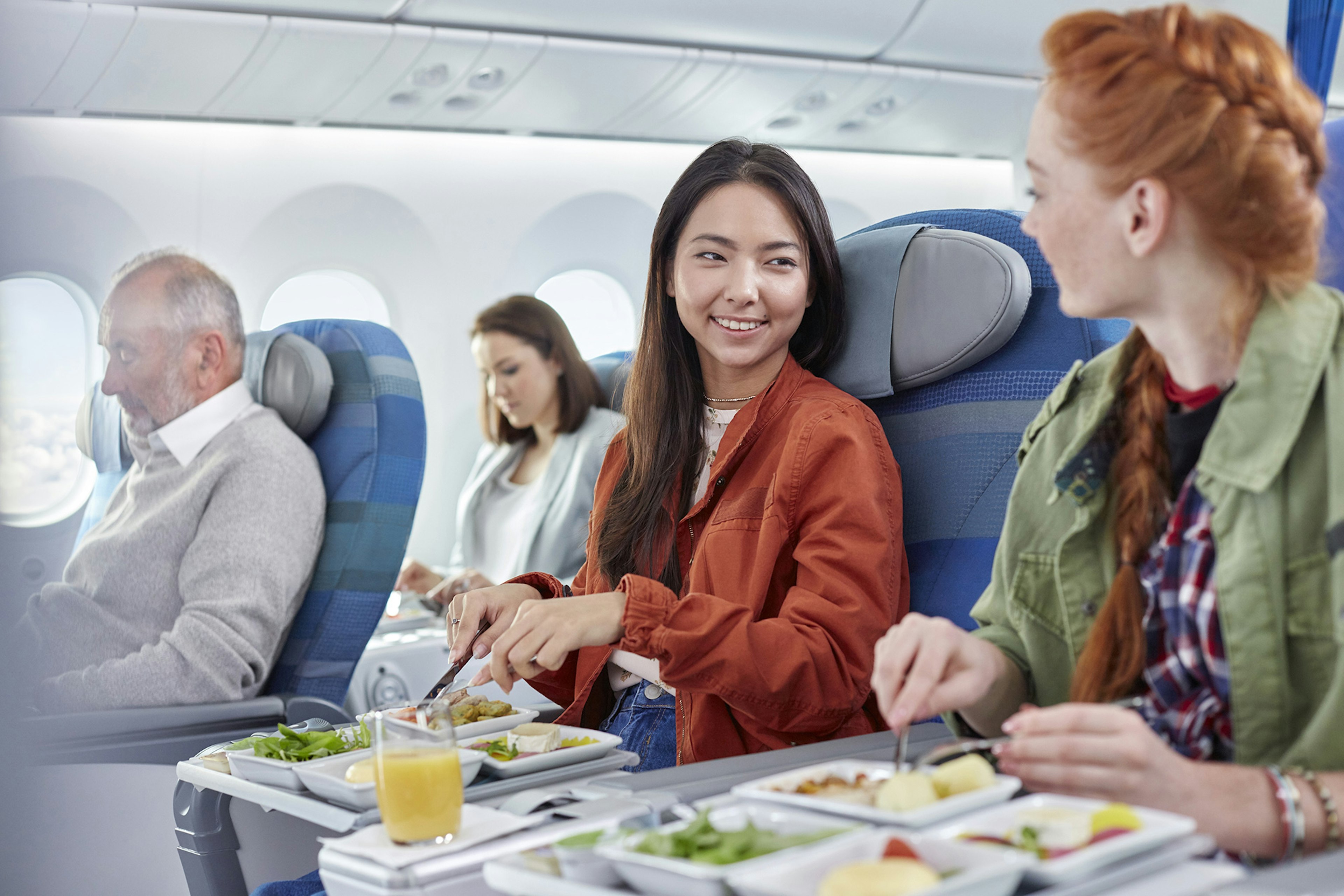 Two women eating on a plane