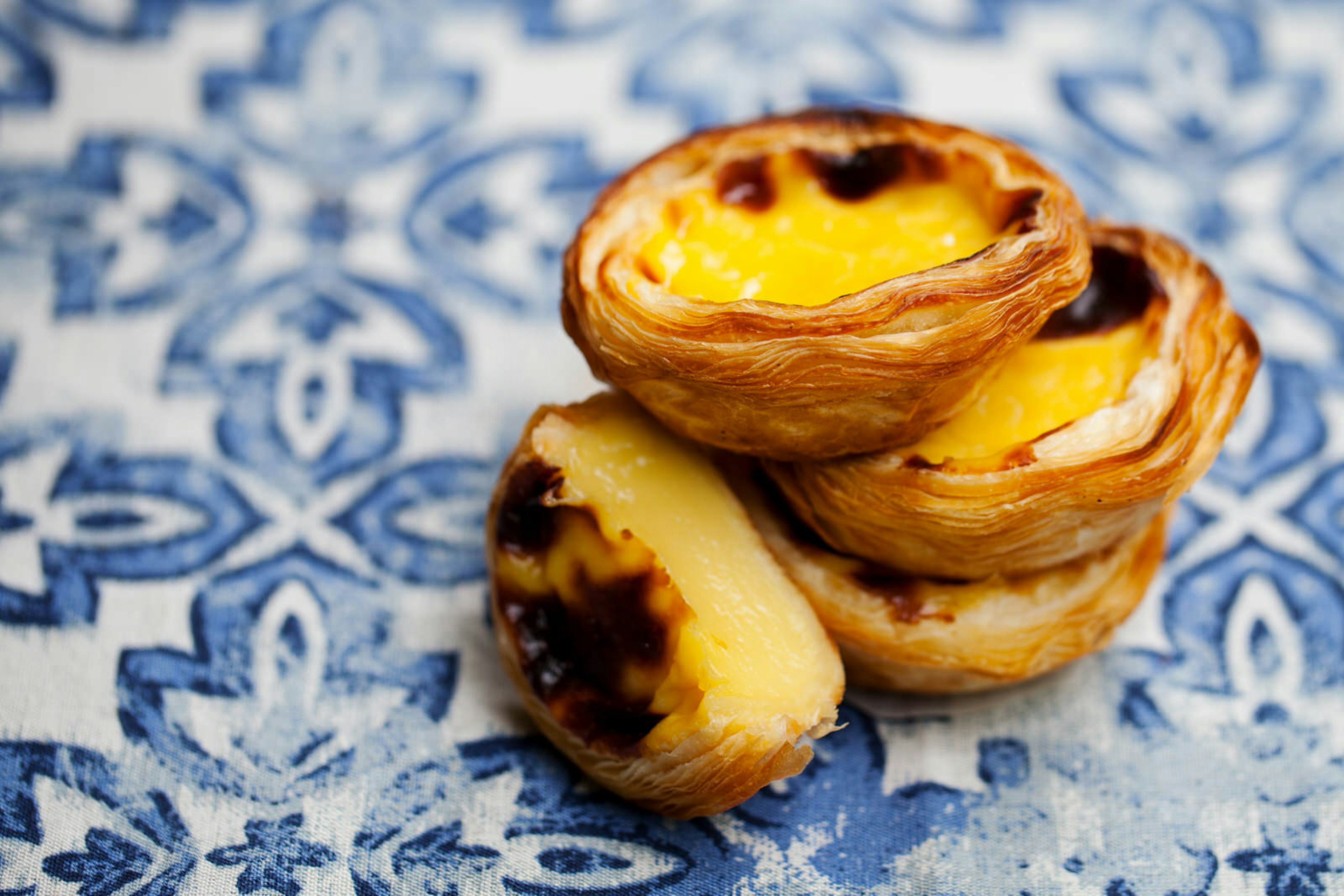 Pastel de nata served on blue and white patterned tiles