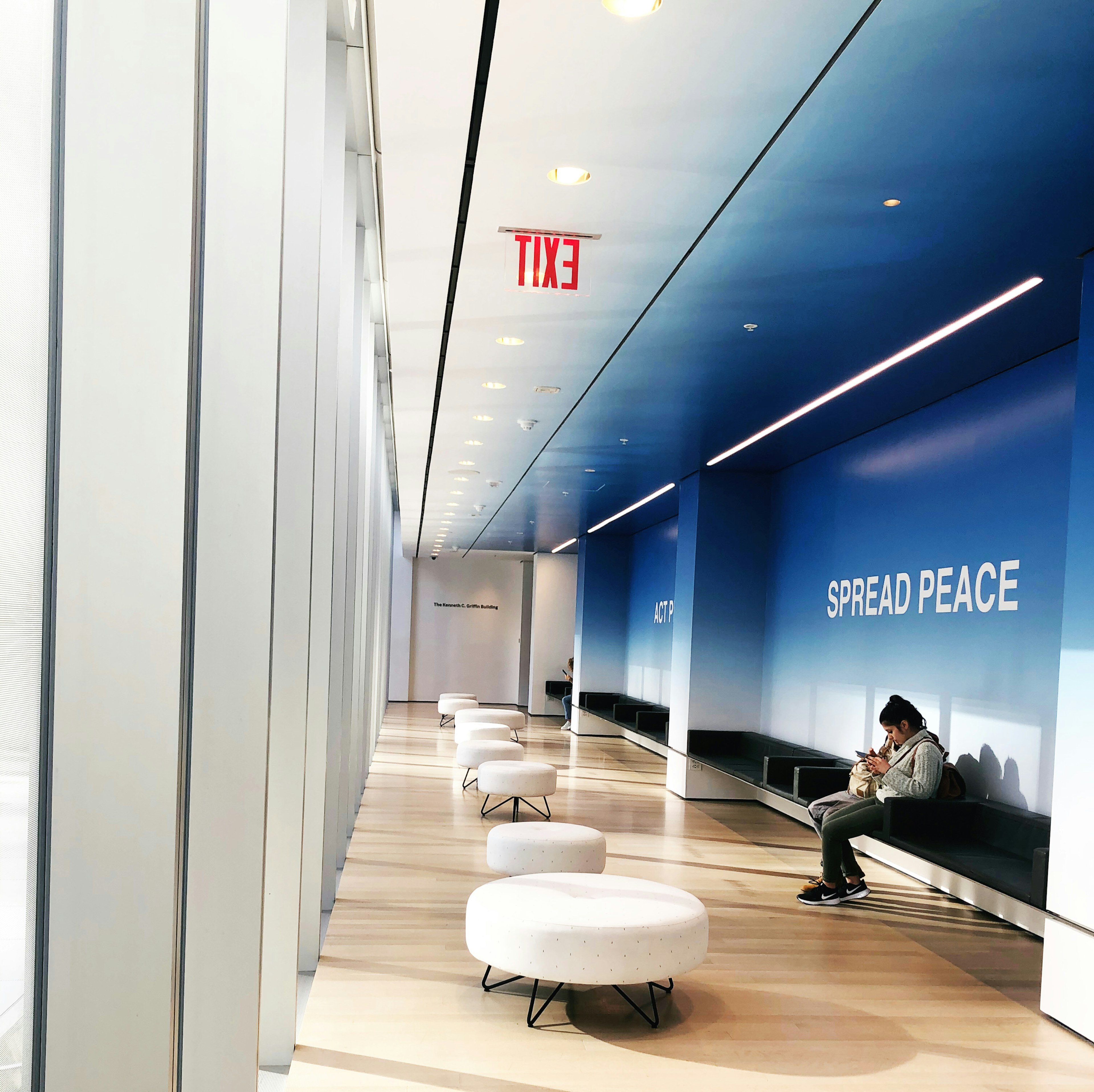 A woman relaxes in a lounge near large windows