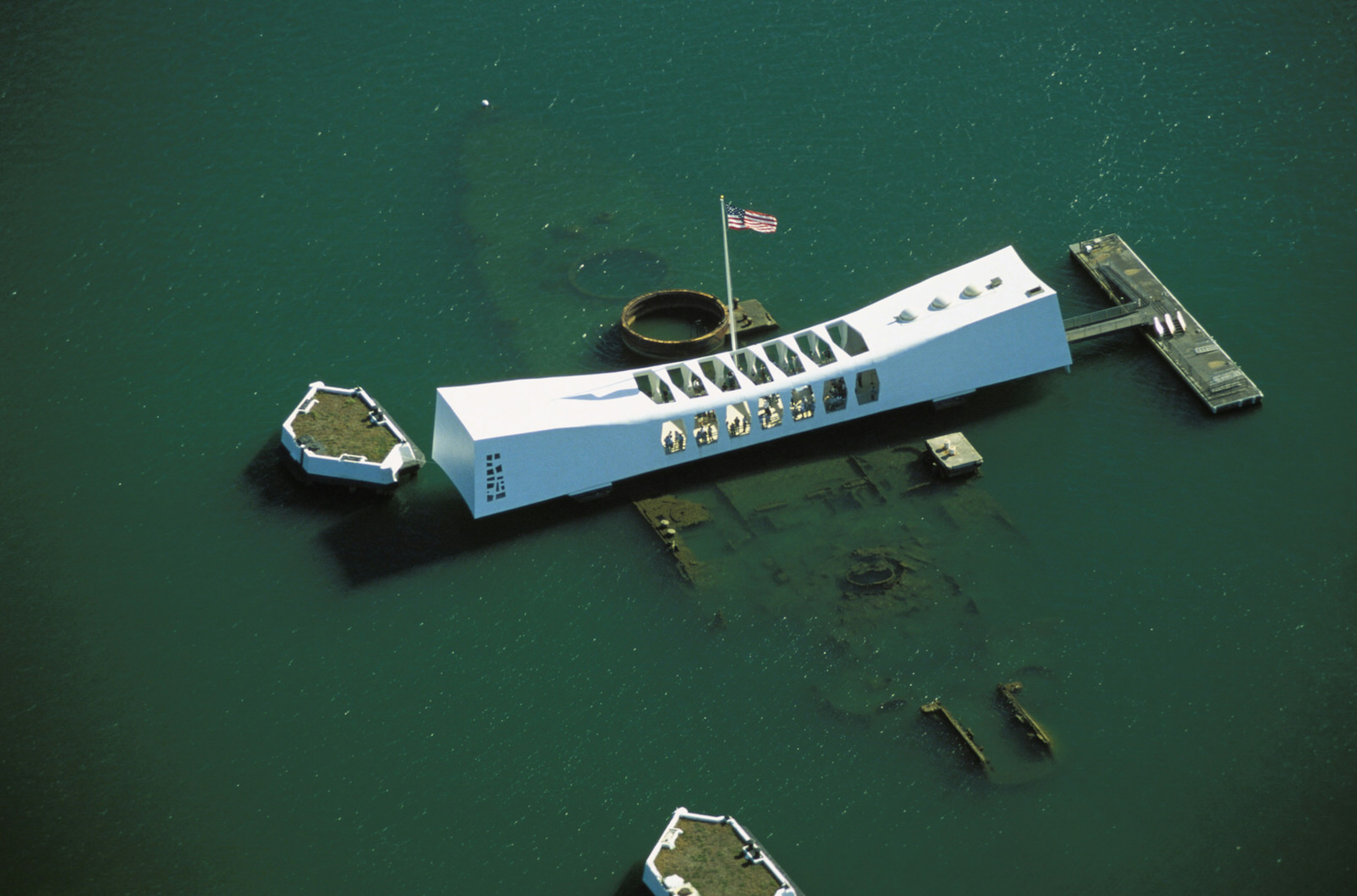 From an overhead birds-eye view, you can see the white USS Arizona memorial and, beneath the water, the remains of the shipwreck © Dana Edmunds / Getty Images