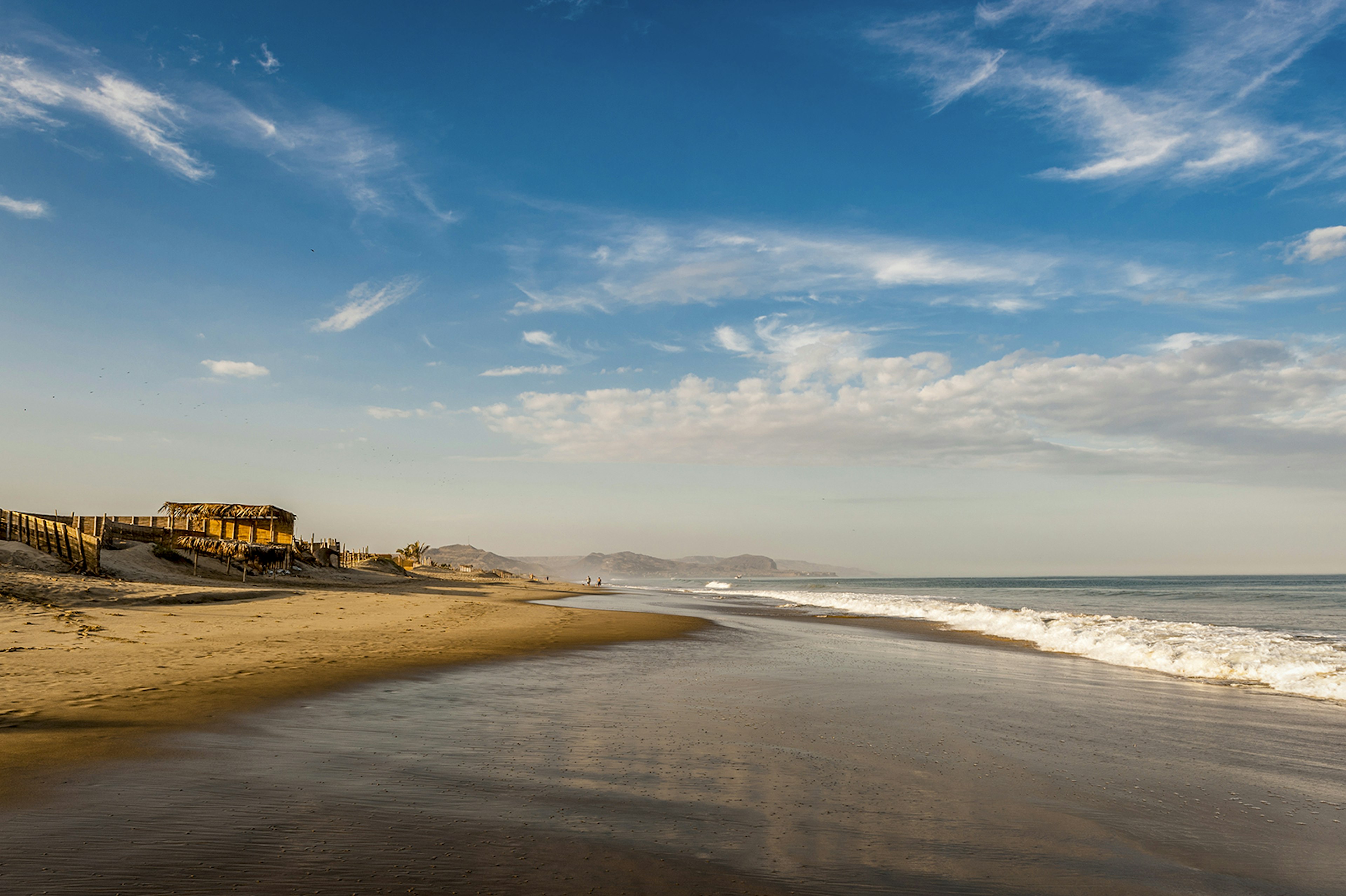 View of coastline with golden sand and blue sky © Xeni4ka / Getty Images