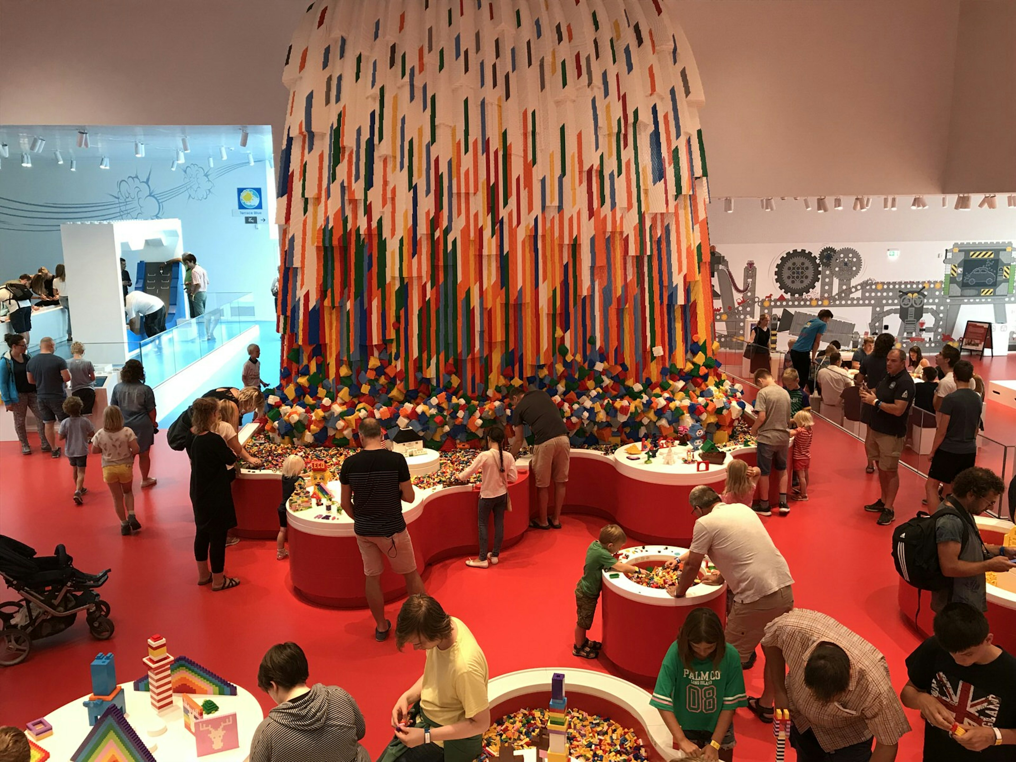 Adults and children playing with brightly-coloured Lego bricks inside the Lego House in Billund © Abigail Blasi / Lonely Planet