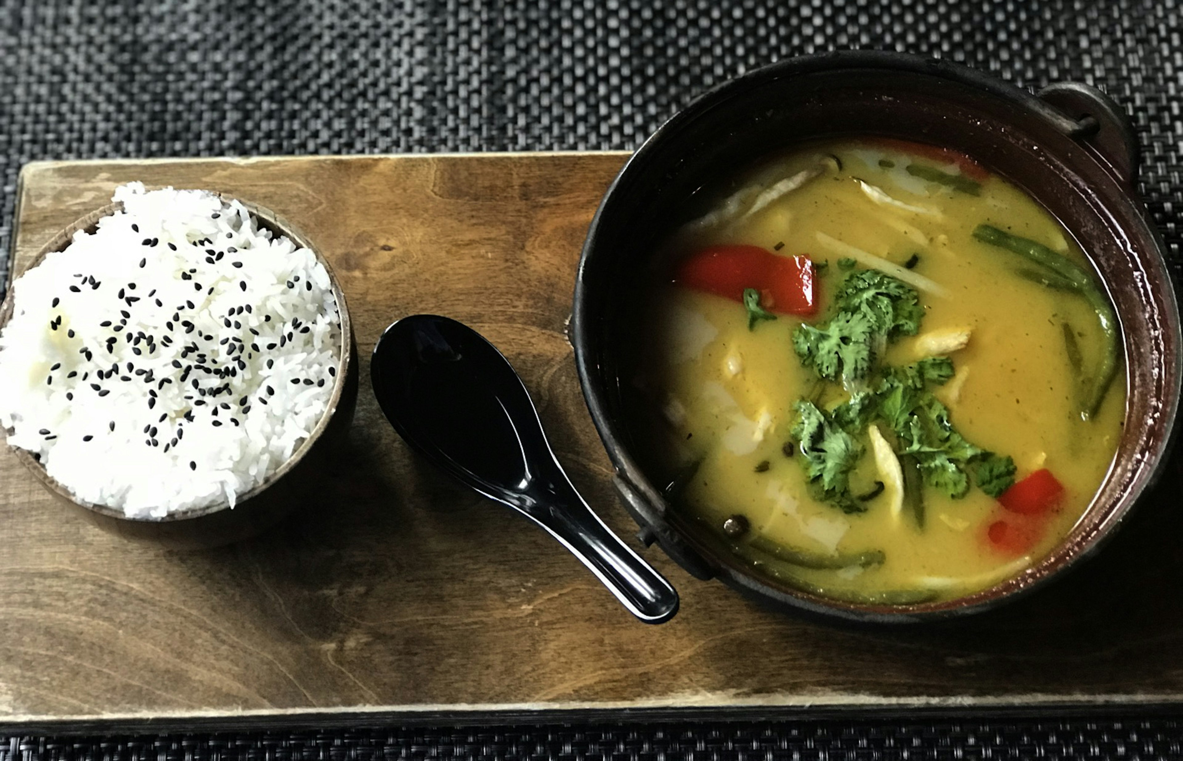 A bowl of rice and an Asian soup are separated right and left by an Asian soup spoon in Mont-Tremblant.