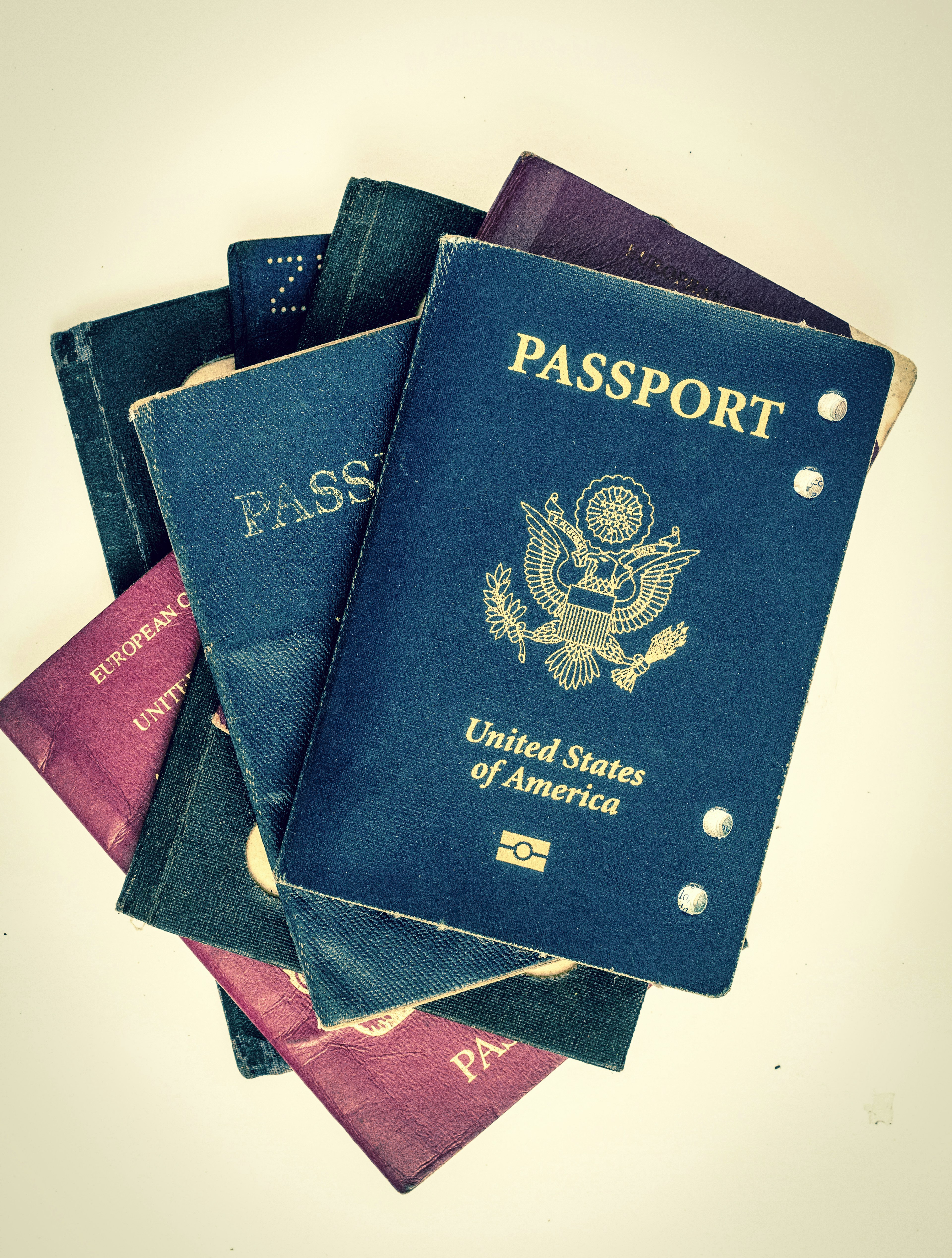 A pile of passports over a cream background