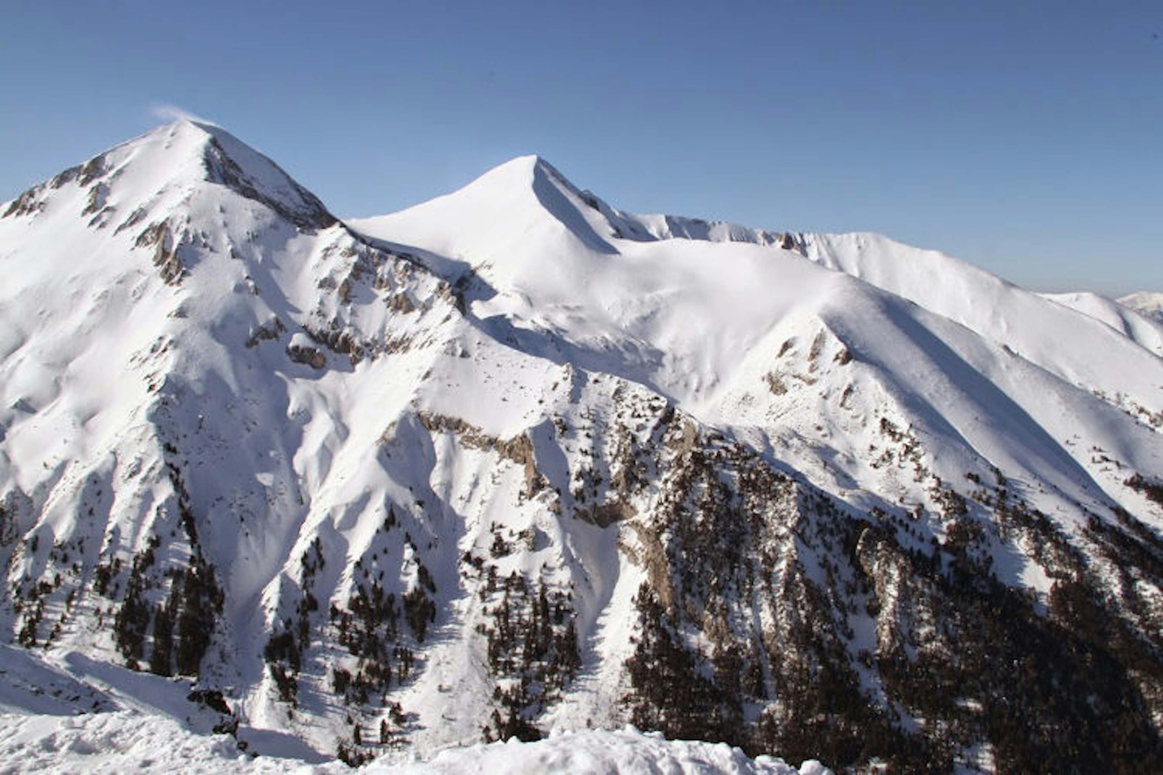 A mountain range with two distinct peaks covered in snow