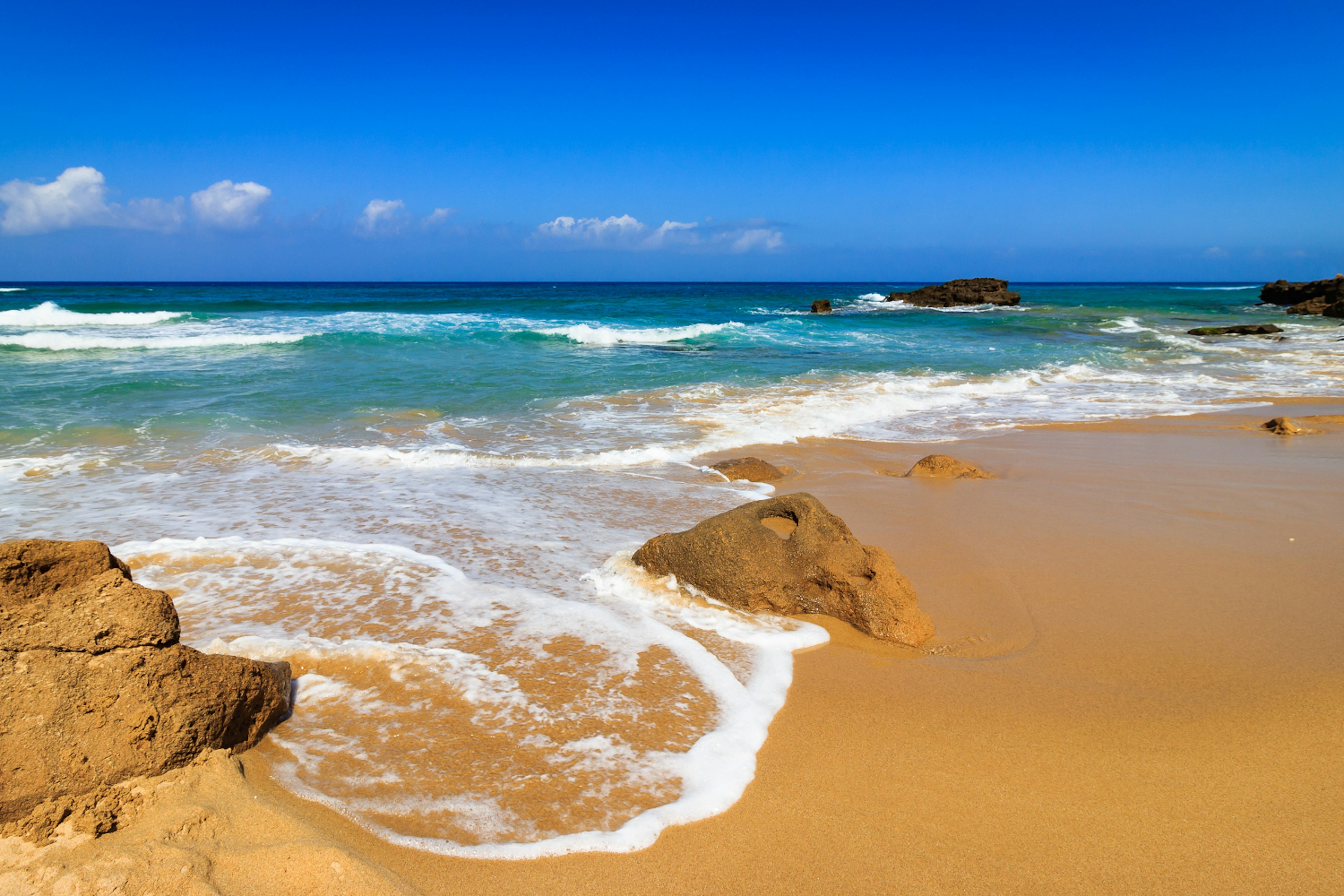 Waves hit the shore of Spiaggia di Piscinas in Sardinia.