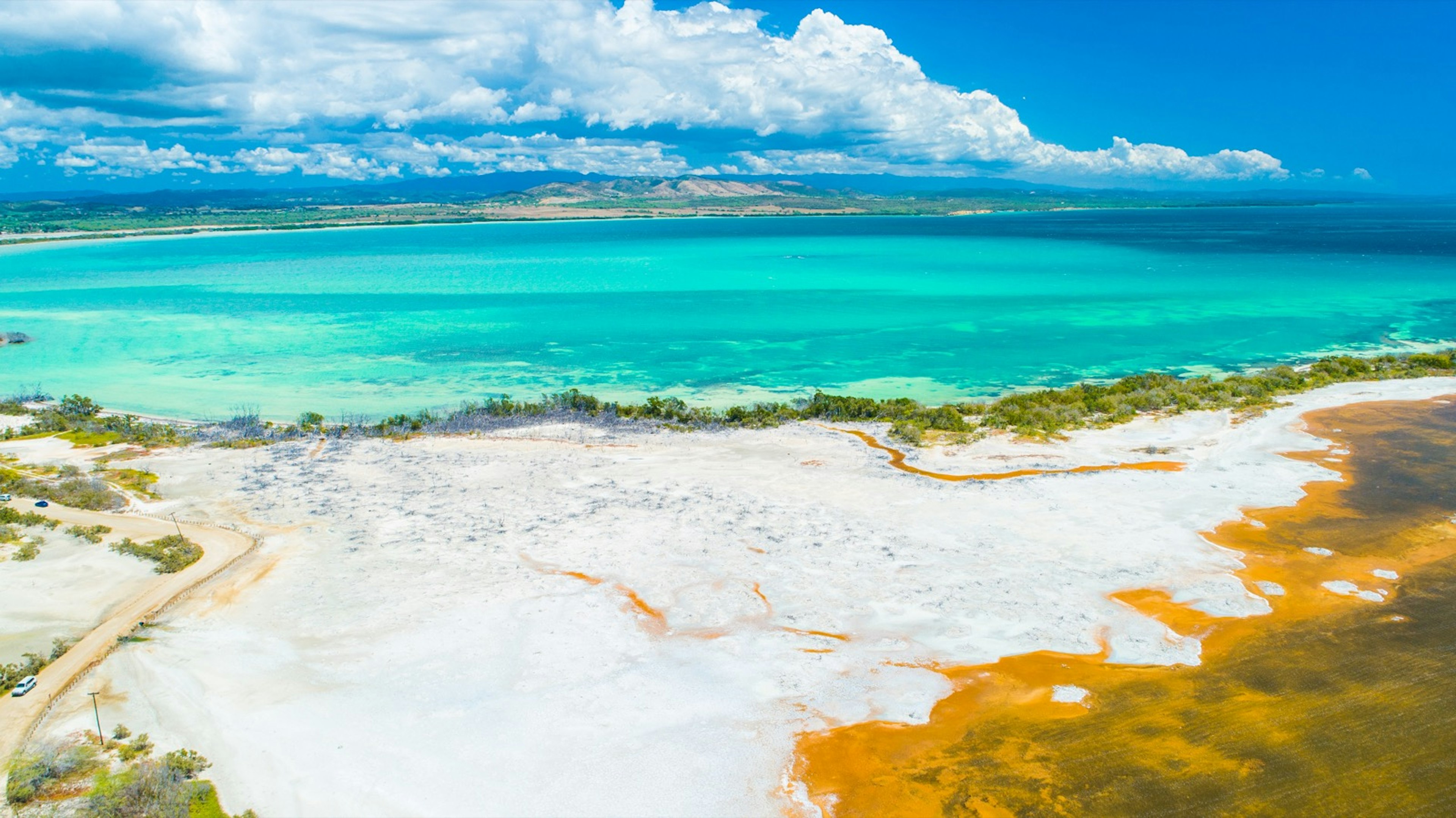 Pristine turquoise ocean lapping against pale white sands