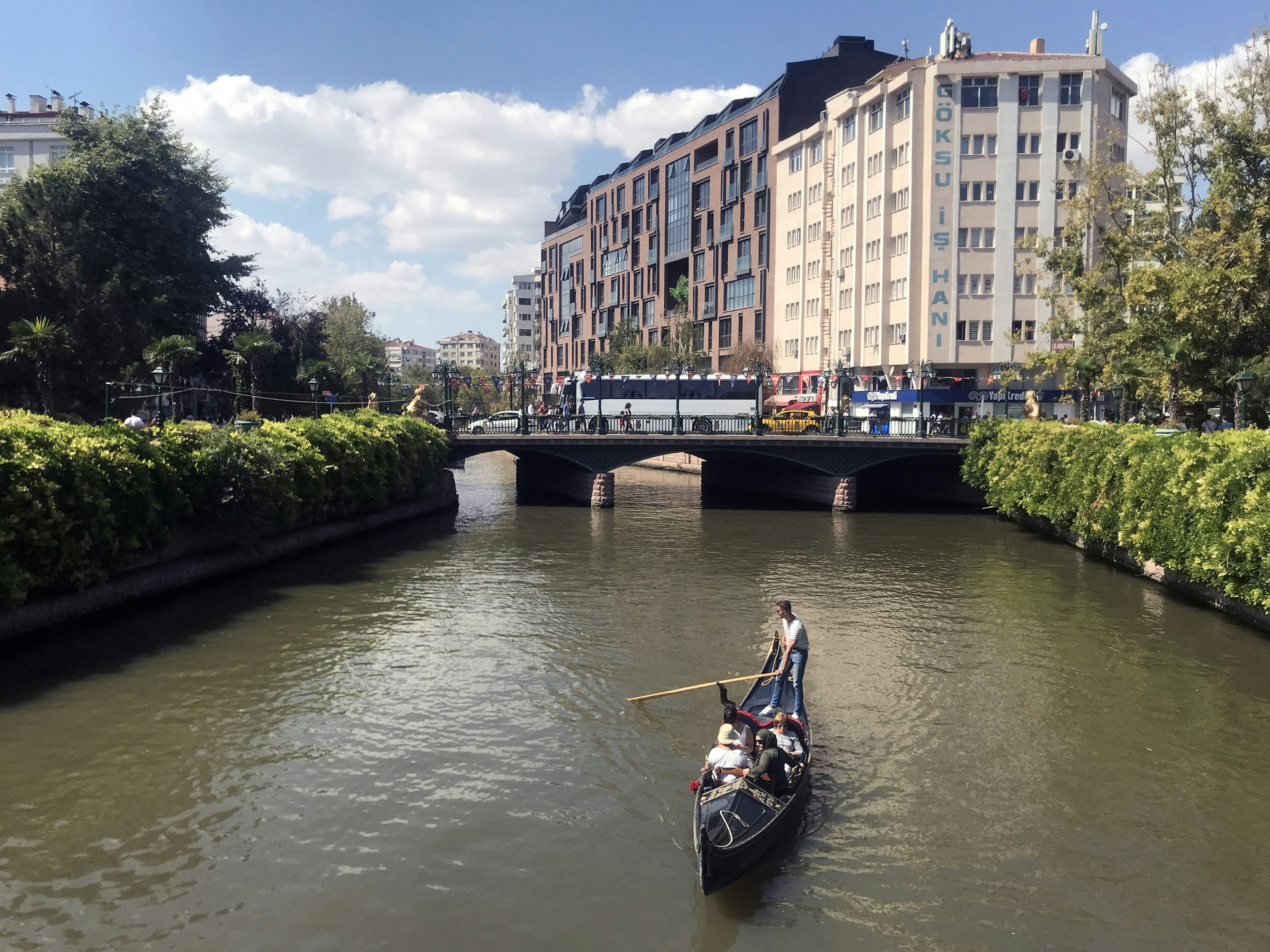 Gondola traveling down a river lined with greenery