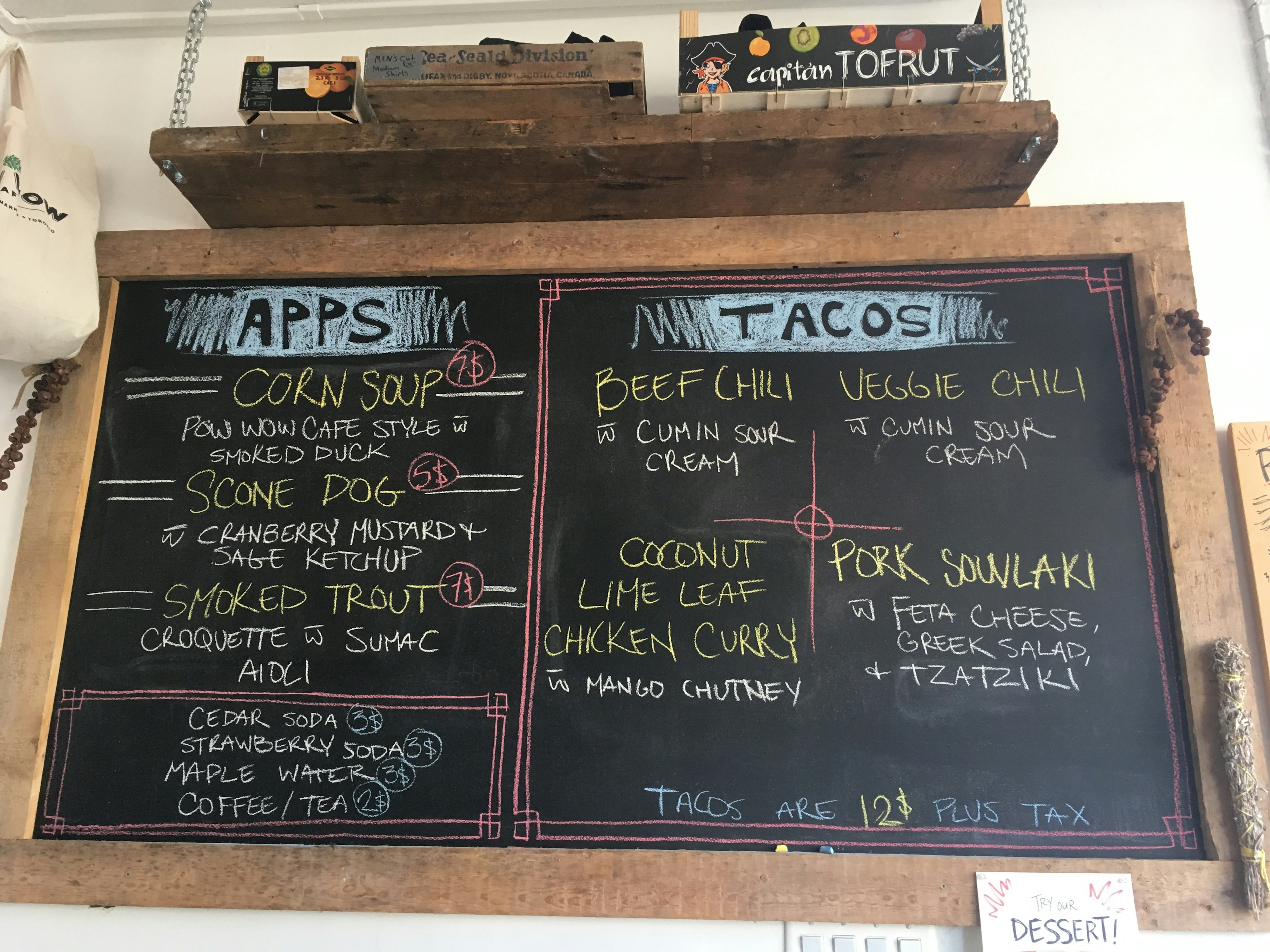 A large chalkboard menu hangs on a wall at Pow Wow Café; Indigenous food