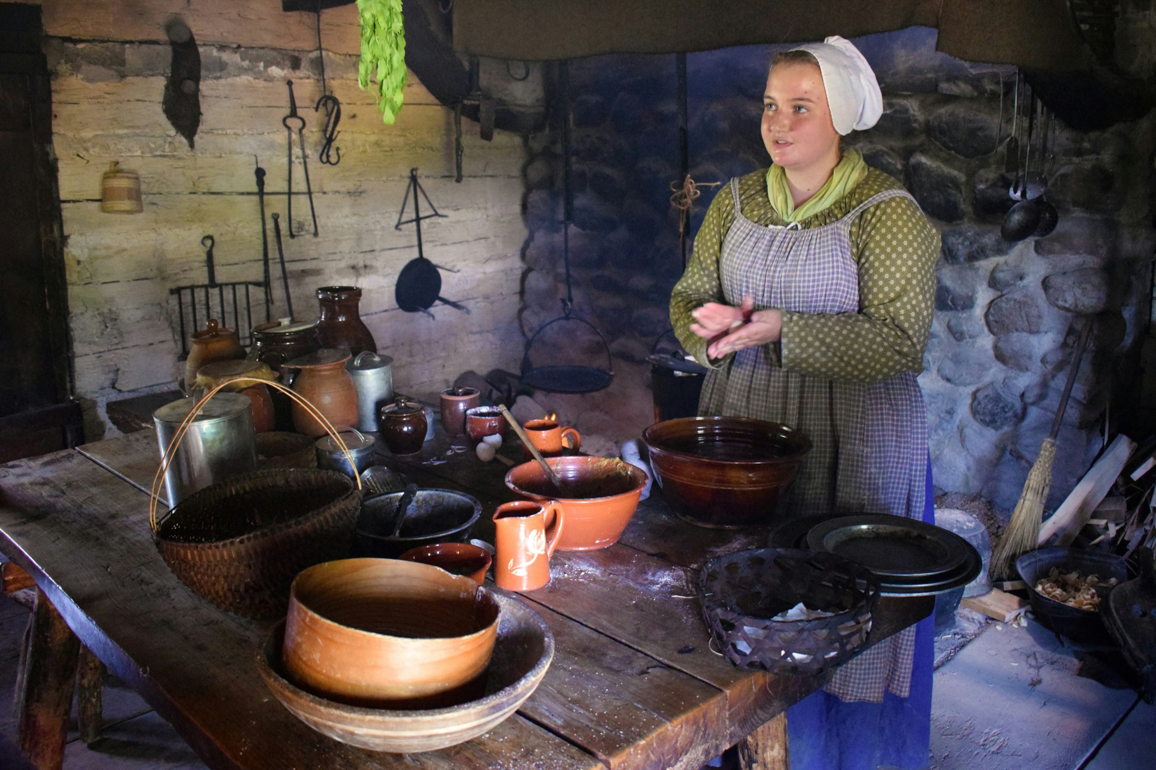 A museum employee in period costume explains live in the 19th Century in Rochester, New York