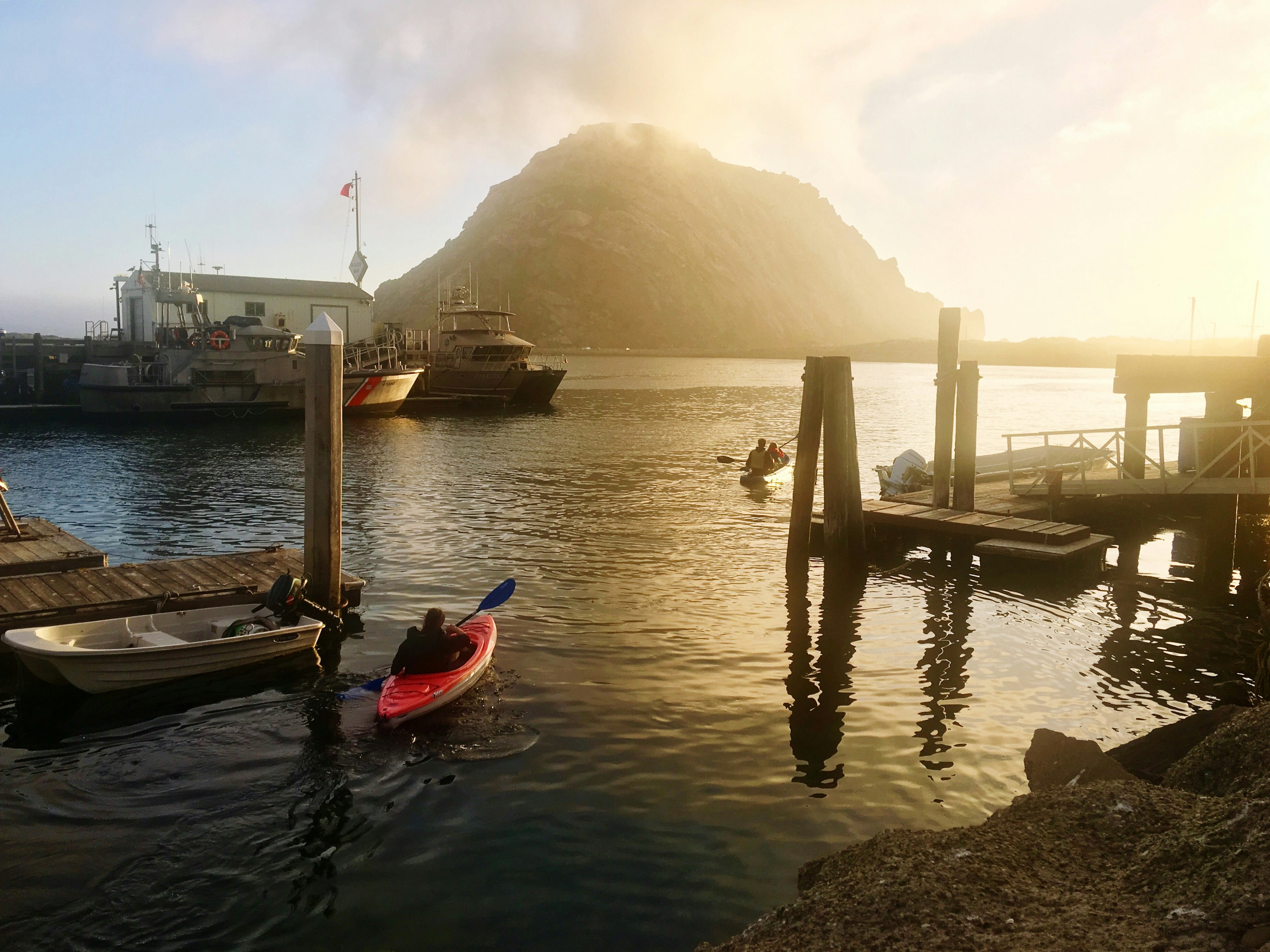 A kayaker heads toward Morro Rock in San Luis Obispo in the early morning at a marina; California ice cream