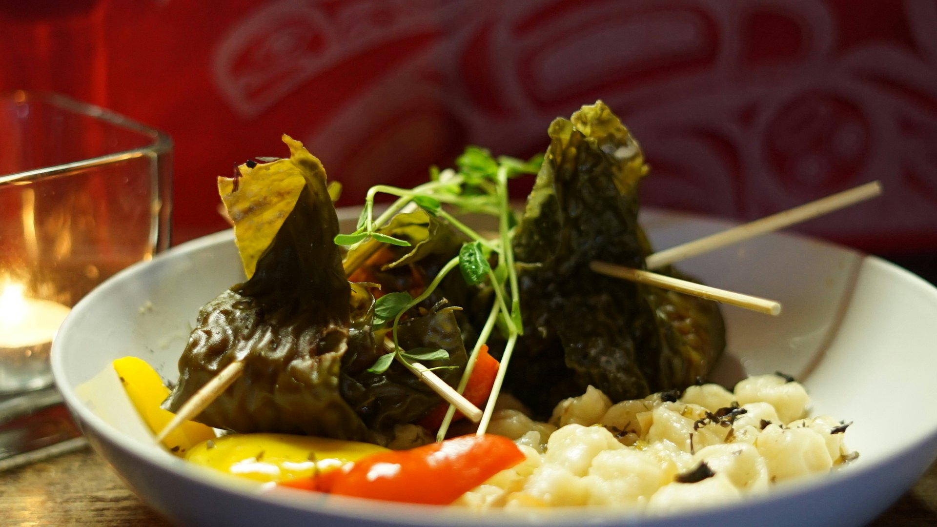 A pair of green dumplings sit in a plate of vegetables; Indigenous food