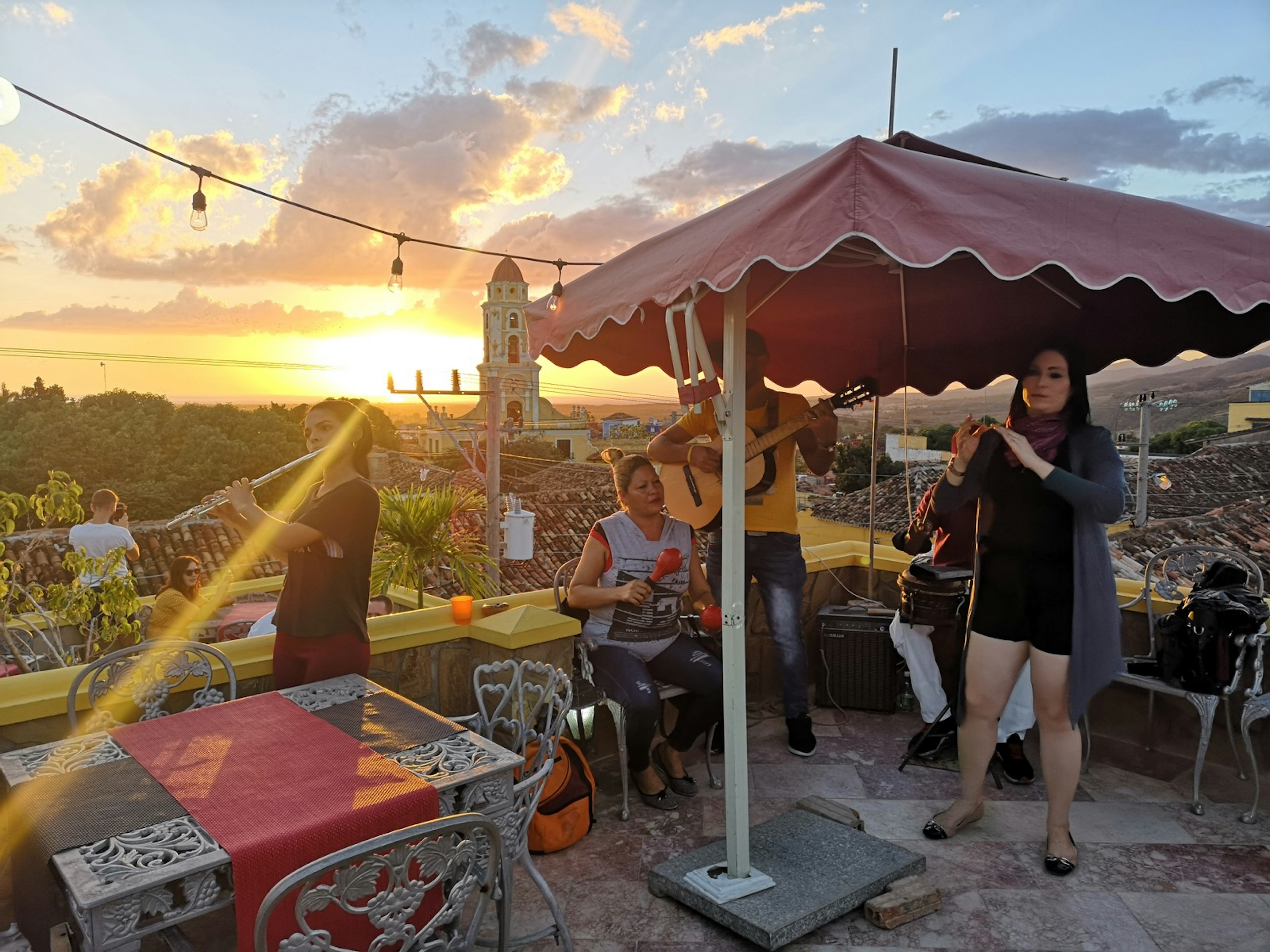 Salsa band performs on a rooftop cafe as the sun sets in Trinidad, Cuba