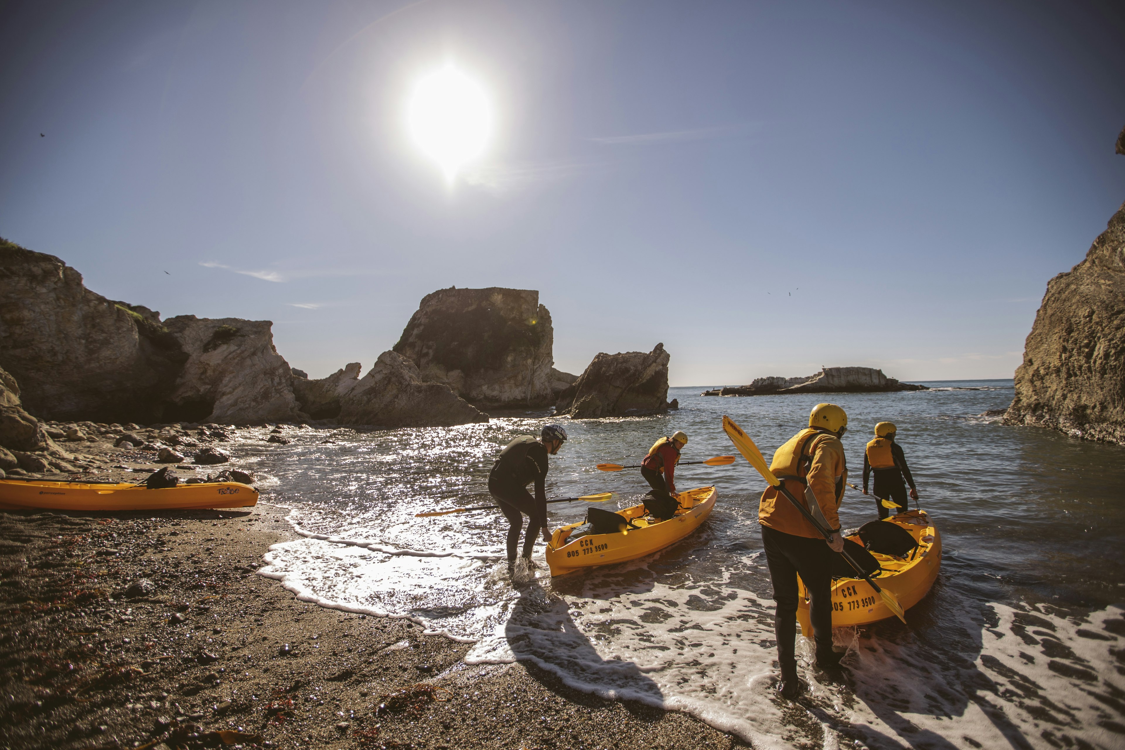 People loading kayaks into the ocean