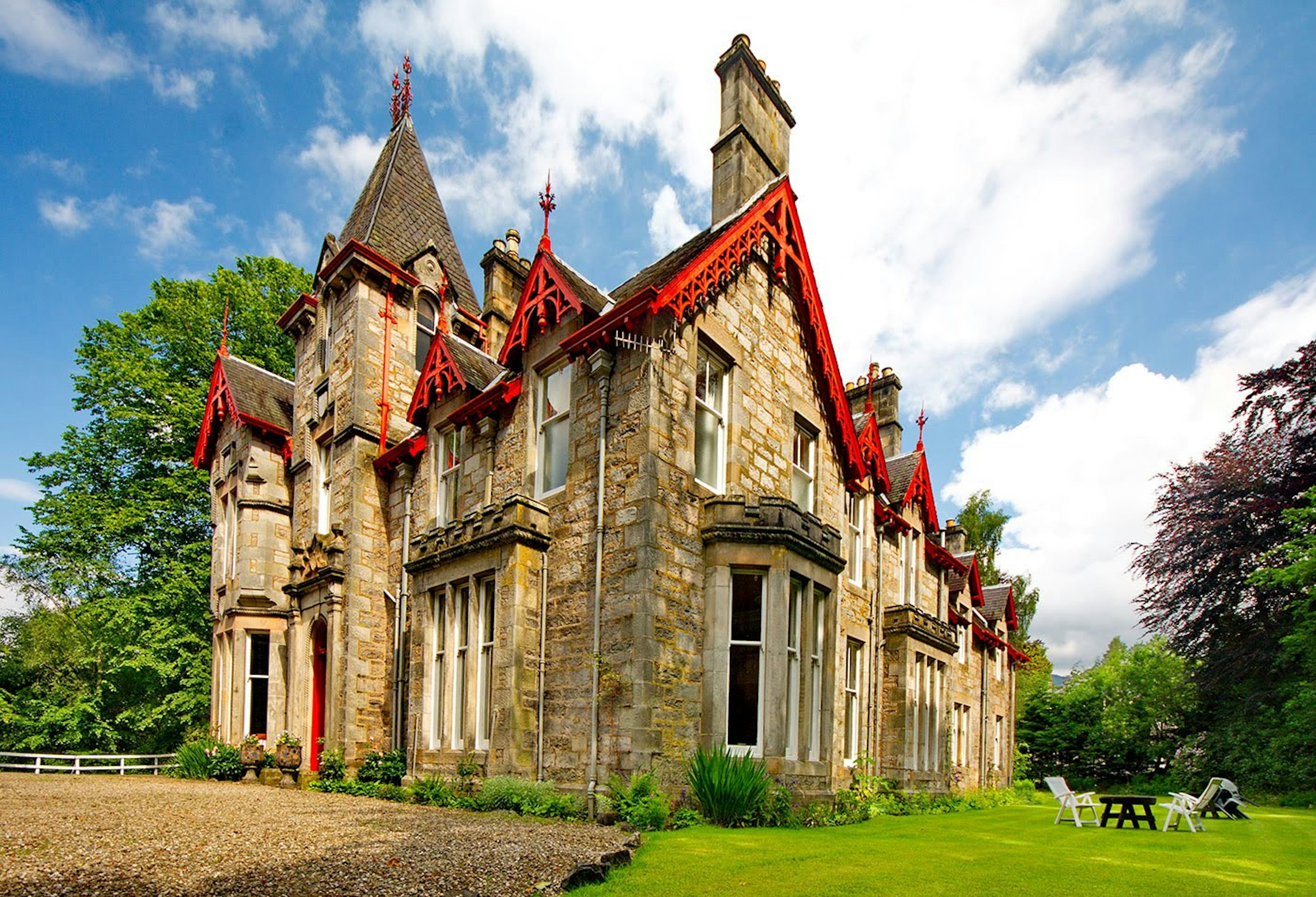 Exterior shot of Saorsa 1875, a castle with red trimmings, that has been converted into a 100 percent vegan hotel.