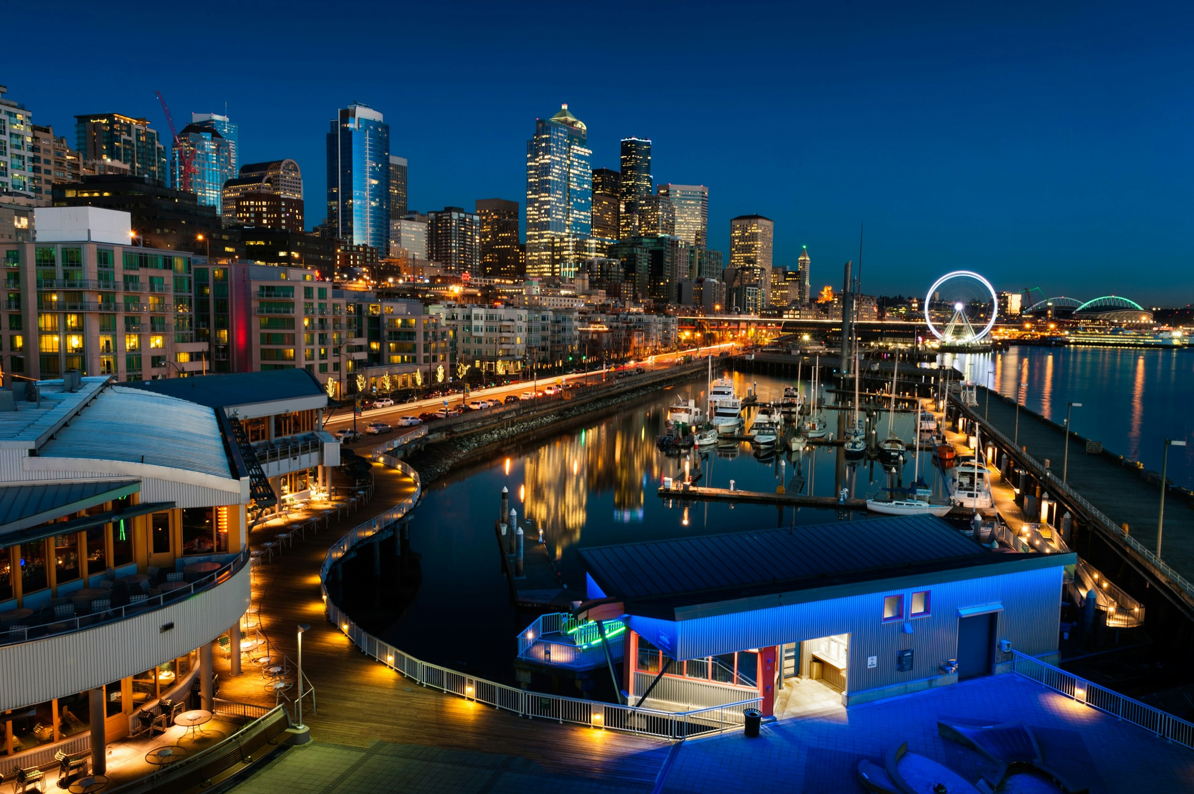 Looking along the Seattle waterfront at dusk as lights and the Ferris wheel are reflected in Puget Sound; Best of Seattle Waterfront