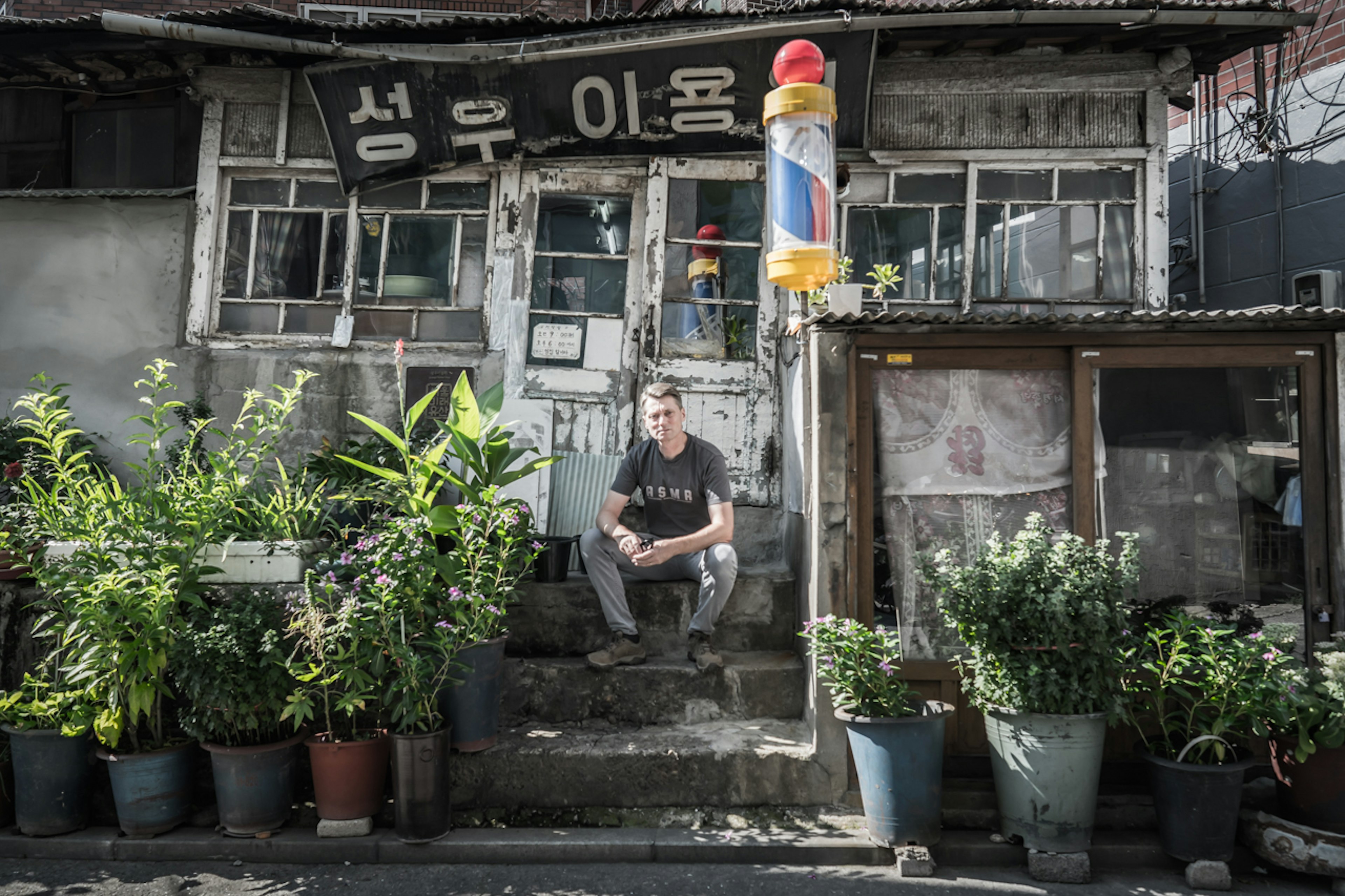 A man sits on steps surrounded by plants in Seongu Seoul South Korea