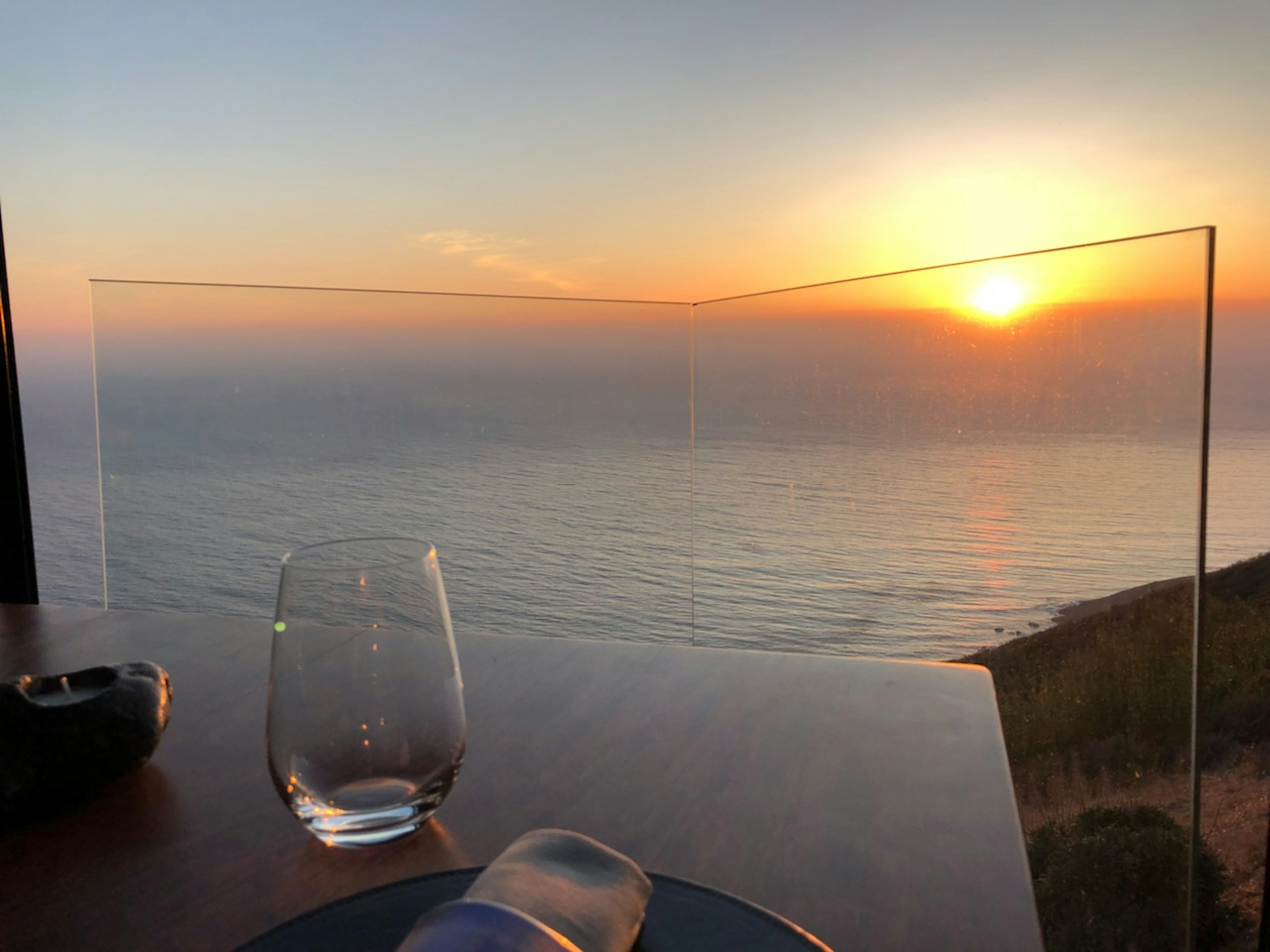 A table is set overlooking the sunset over the pacific ocean