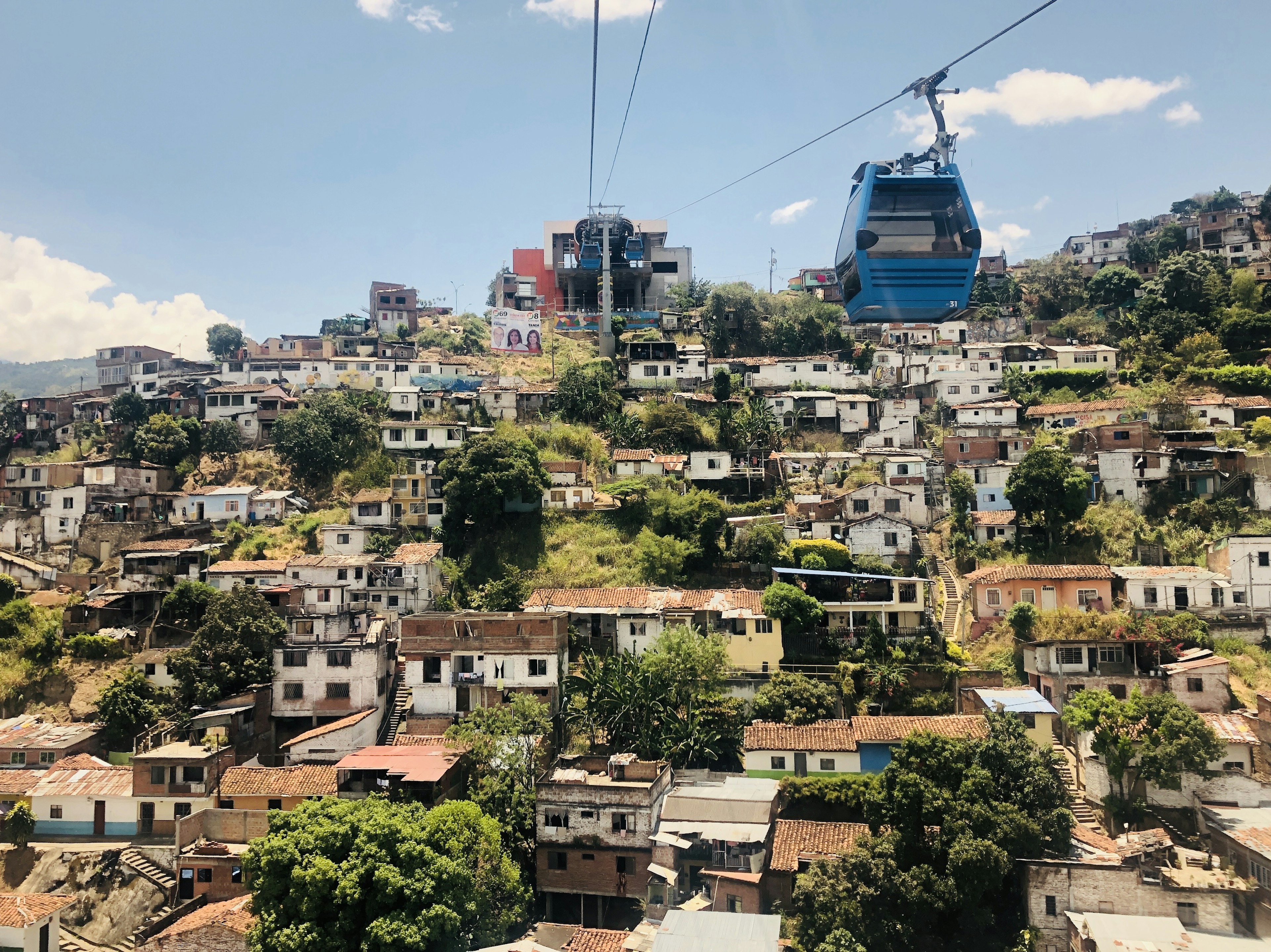 Cable cars travel across the town of Siloe on a sunny day; Cali Colombia