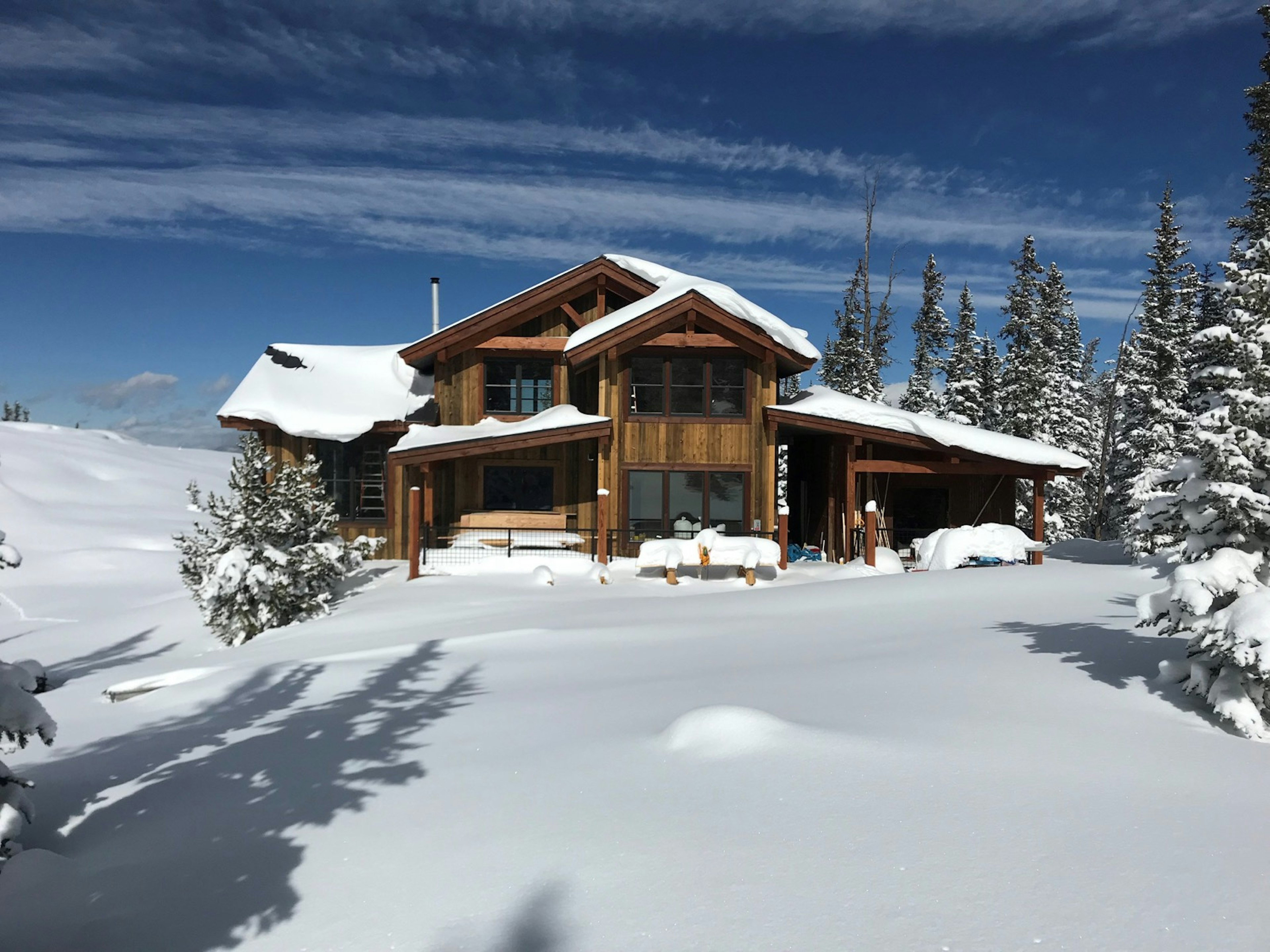 A cabin on a mountain surrounded by snow