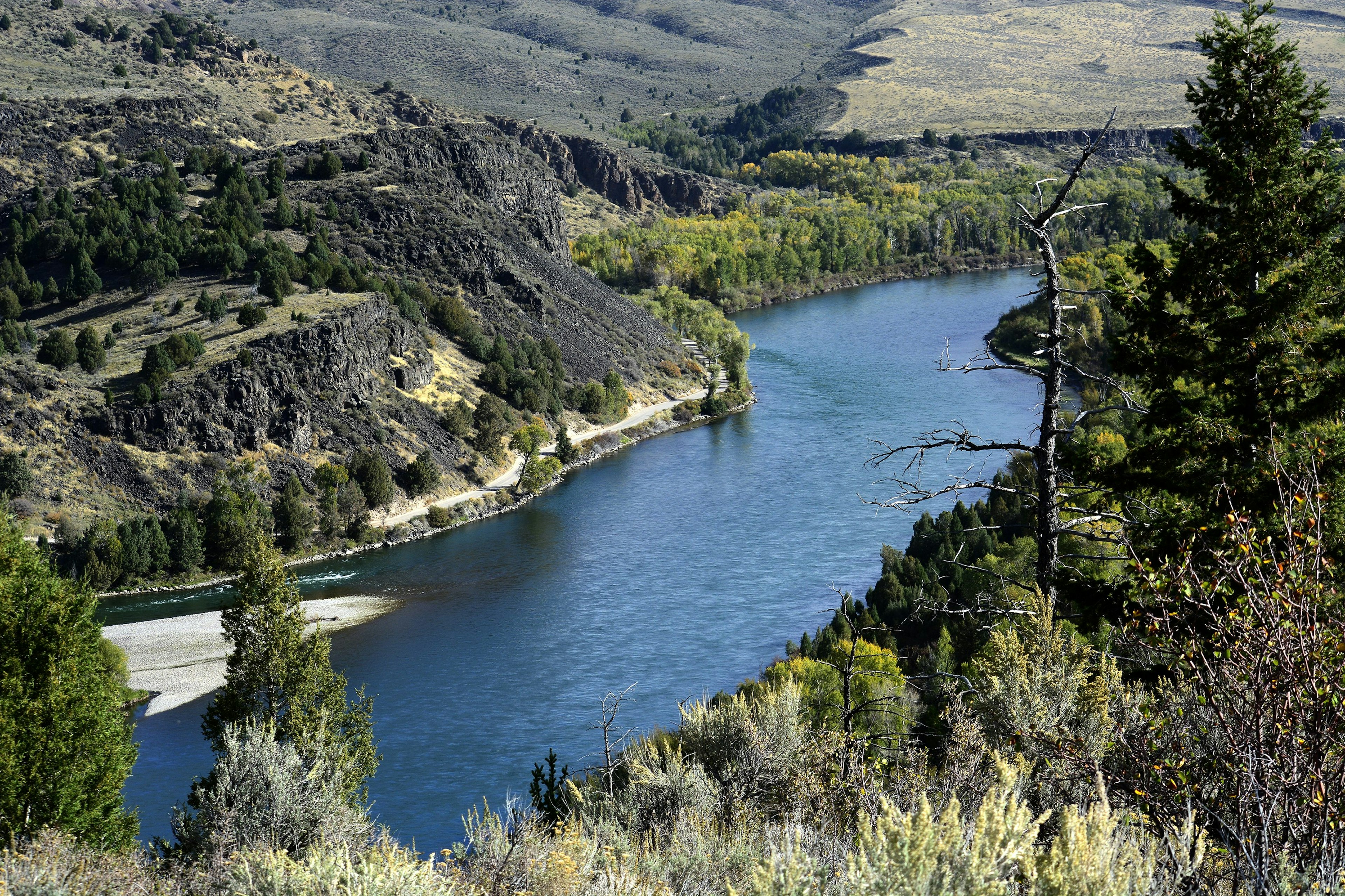 A high-angle photograph of a river snaking through hilly region