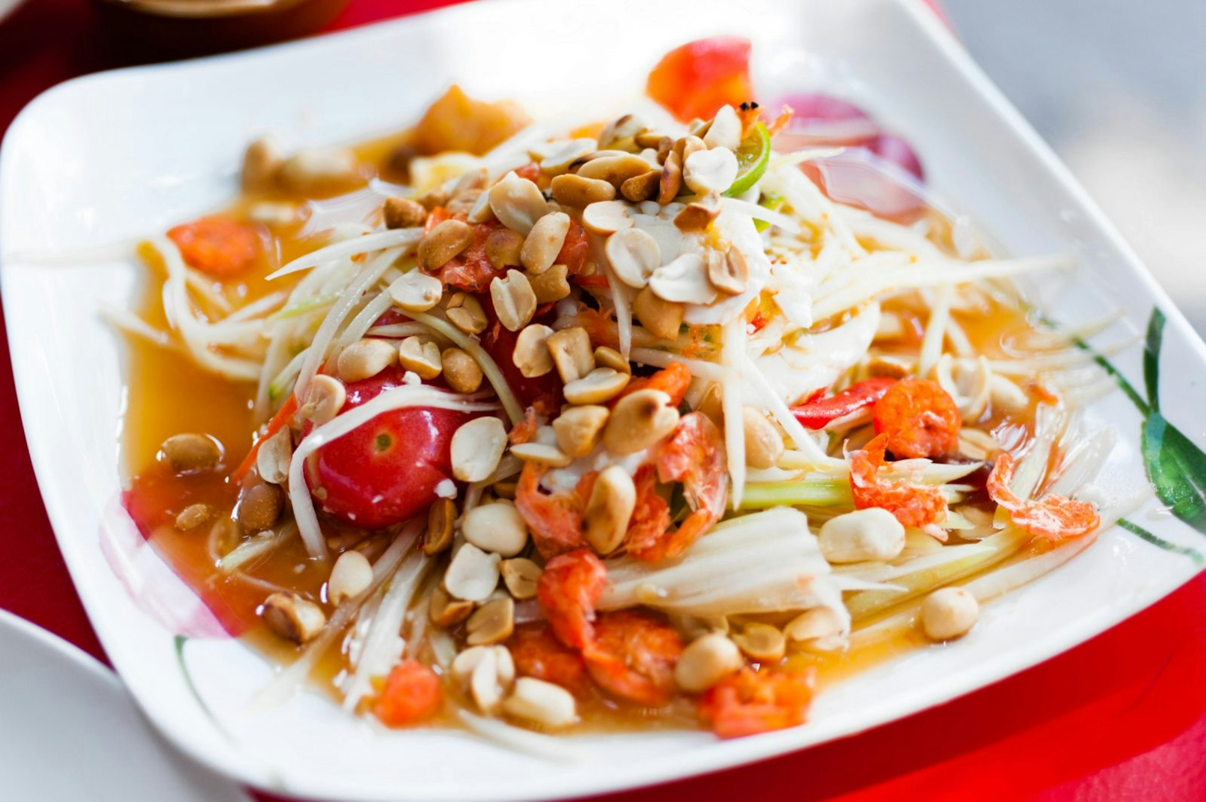 A plate of som tum, a spicy papaya salad with tomatoes, long beans, chilies, garlic, fish sauce and lime © Austin Bush / Lonely Planet