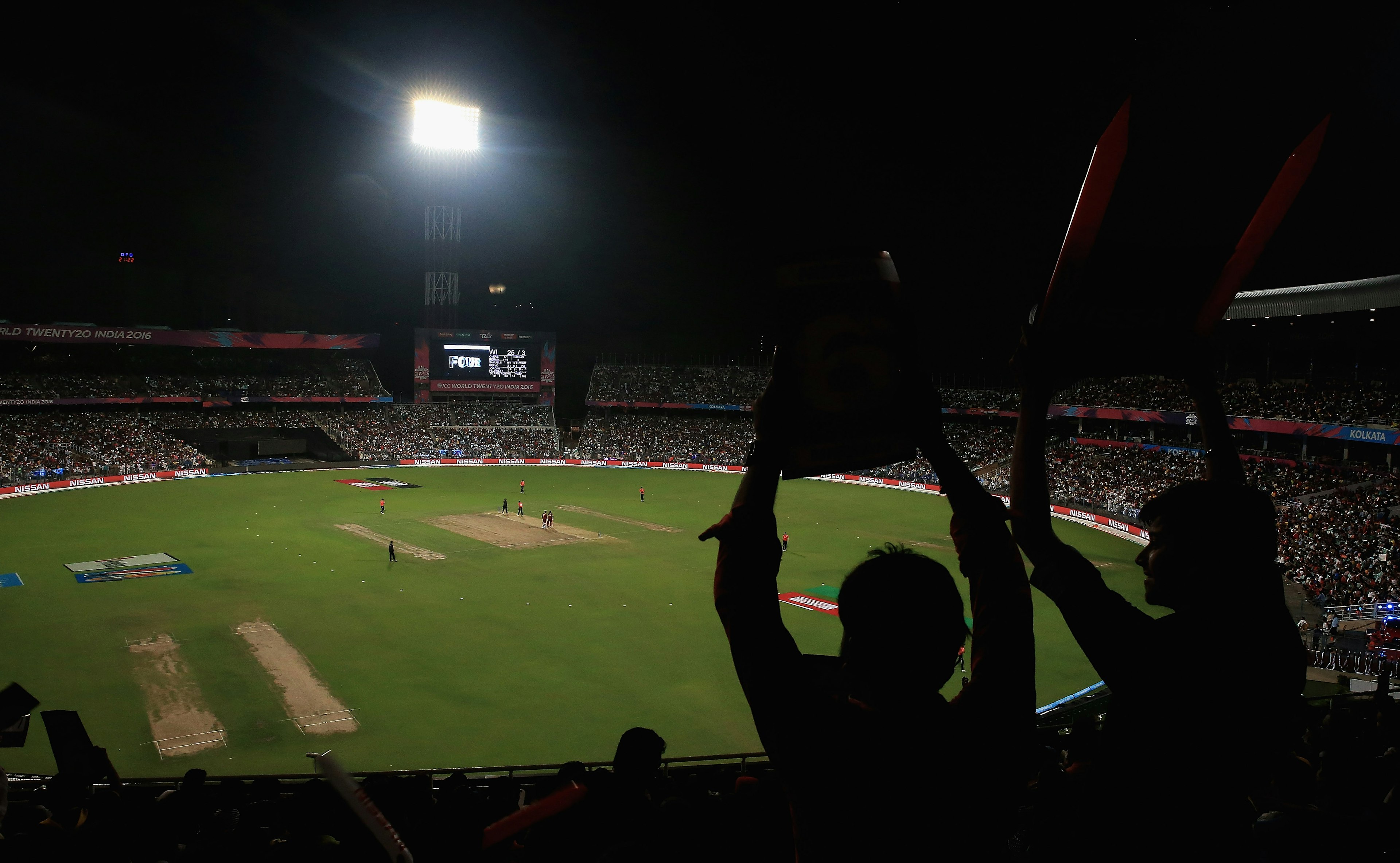 Spectators watch two cricket teams competing at Eden Gardens, Kolkata