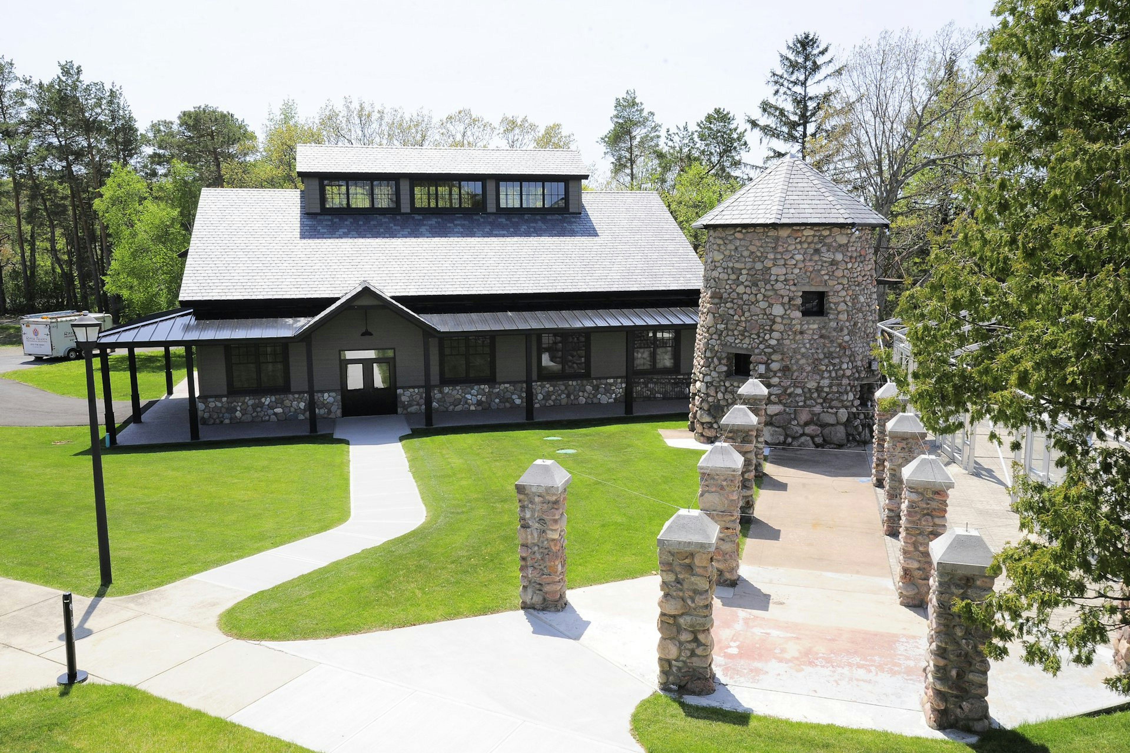 Exterior of the St. Lawerence Distillery; there's a large stone circular structure to the right and a row of smaller stone structures leading to it; unusual distilleries