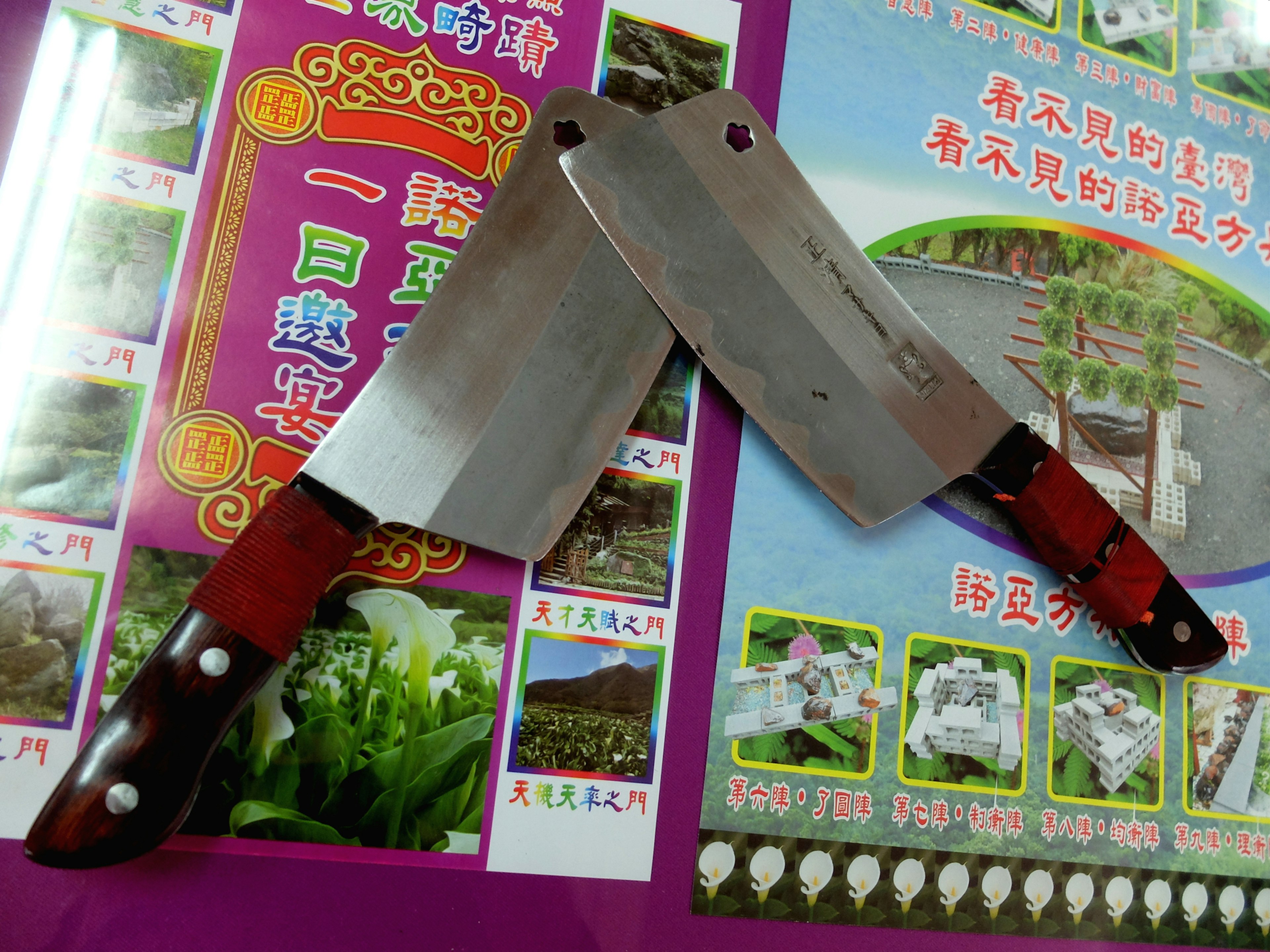 Two large blunt knives that look like cleavers lie on a desk.