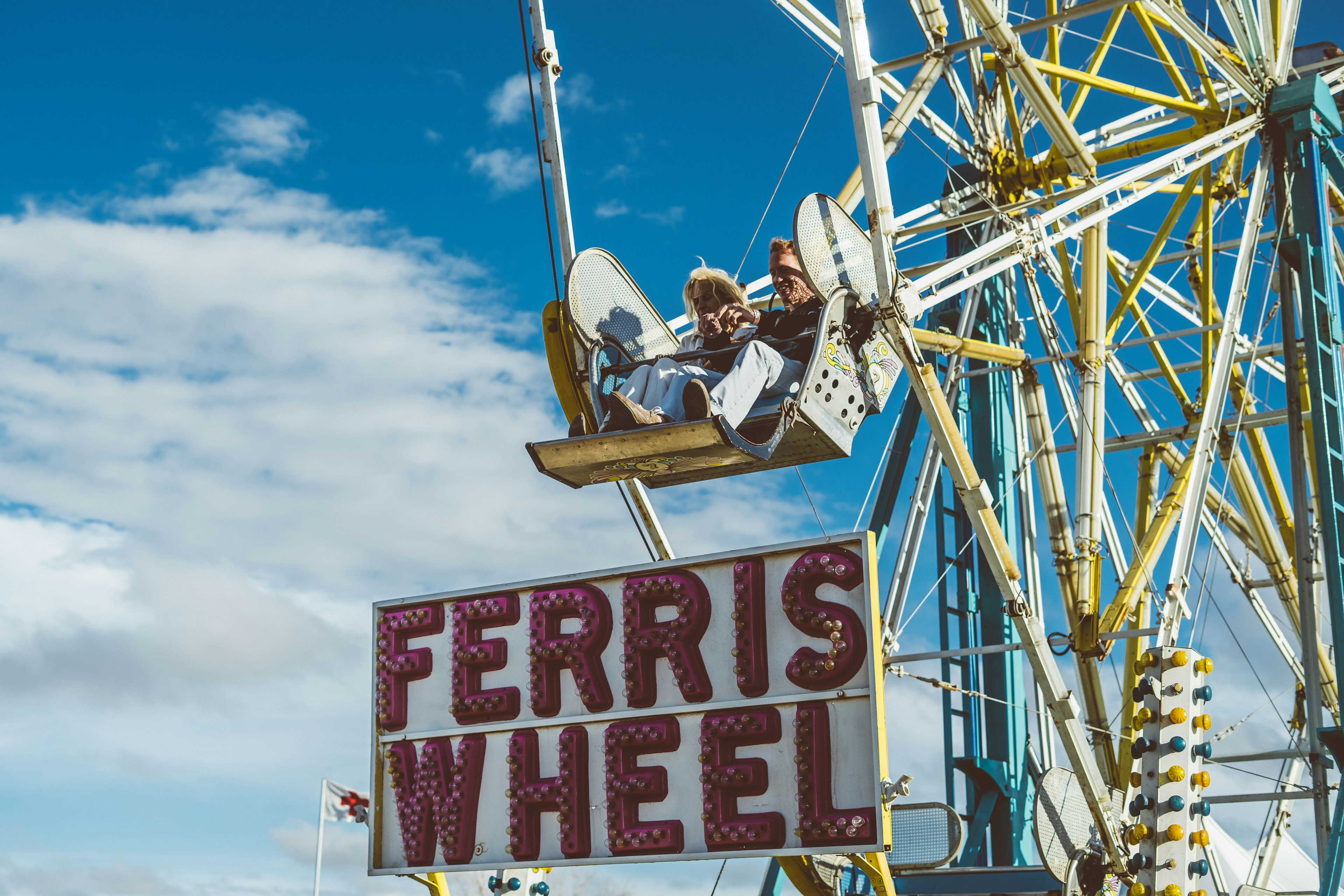 Two people on a ferris wheel at Trans-Pecos Festival in Marfa, Texas on a clear sunny day.