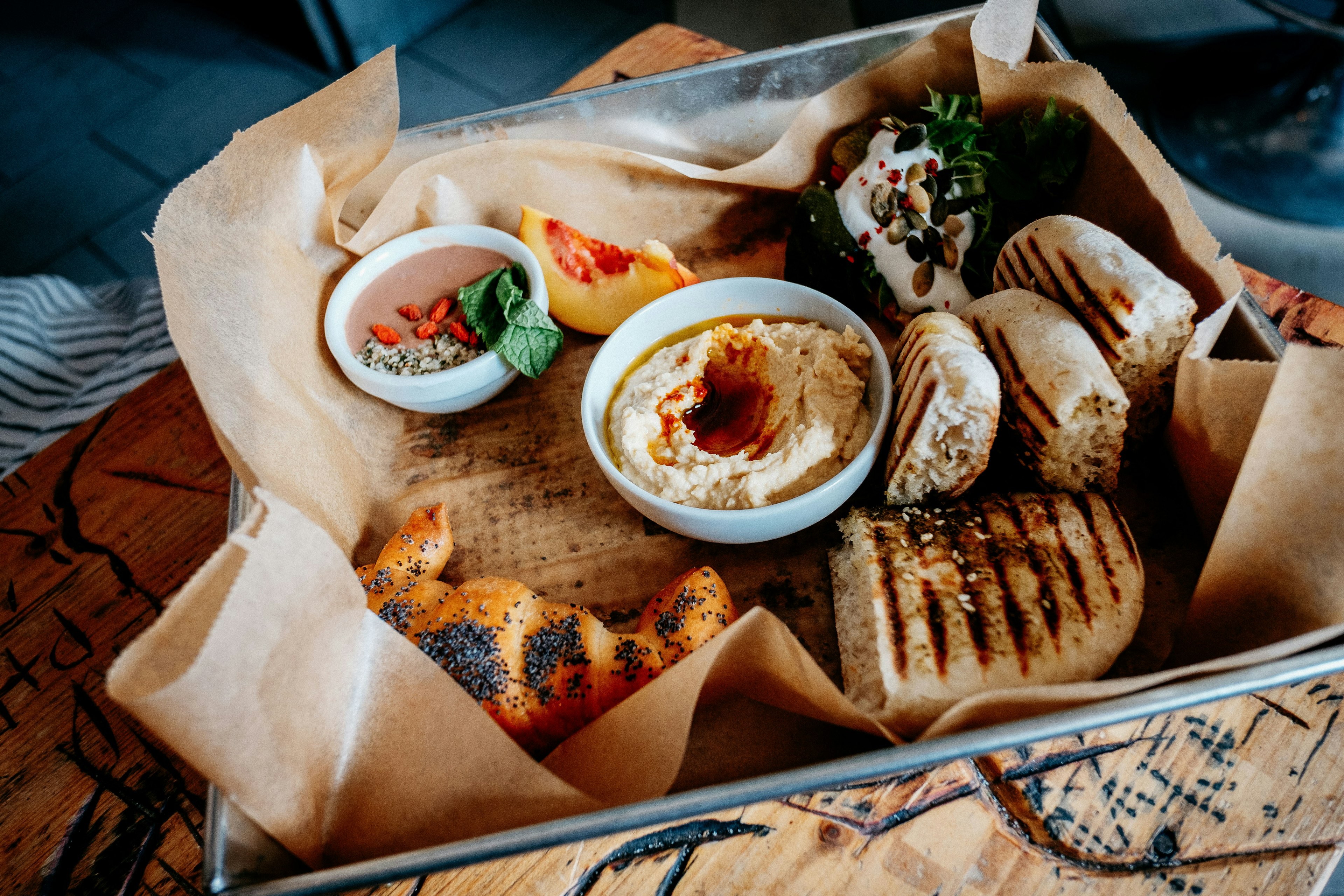 Chargrilled bread, hummus and other dips are arranged in a metal tray lined with baking parchment as part of the Taste of Prague Food Tour.