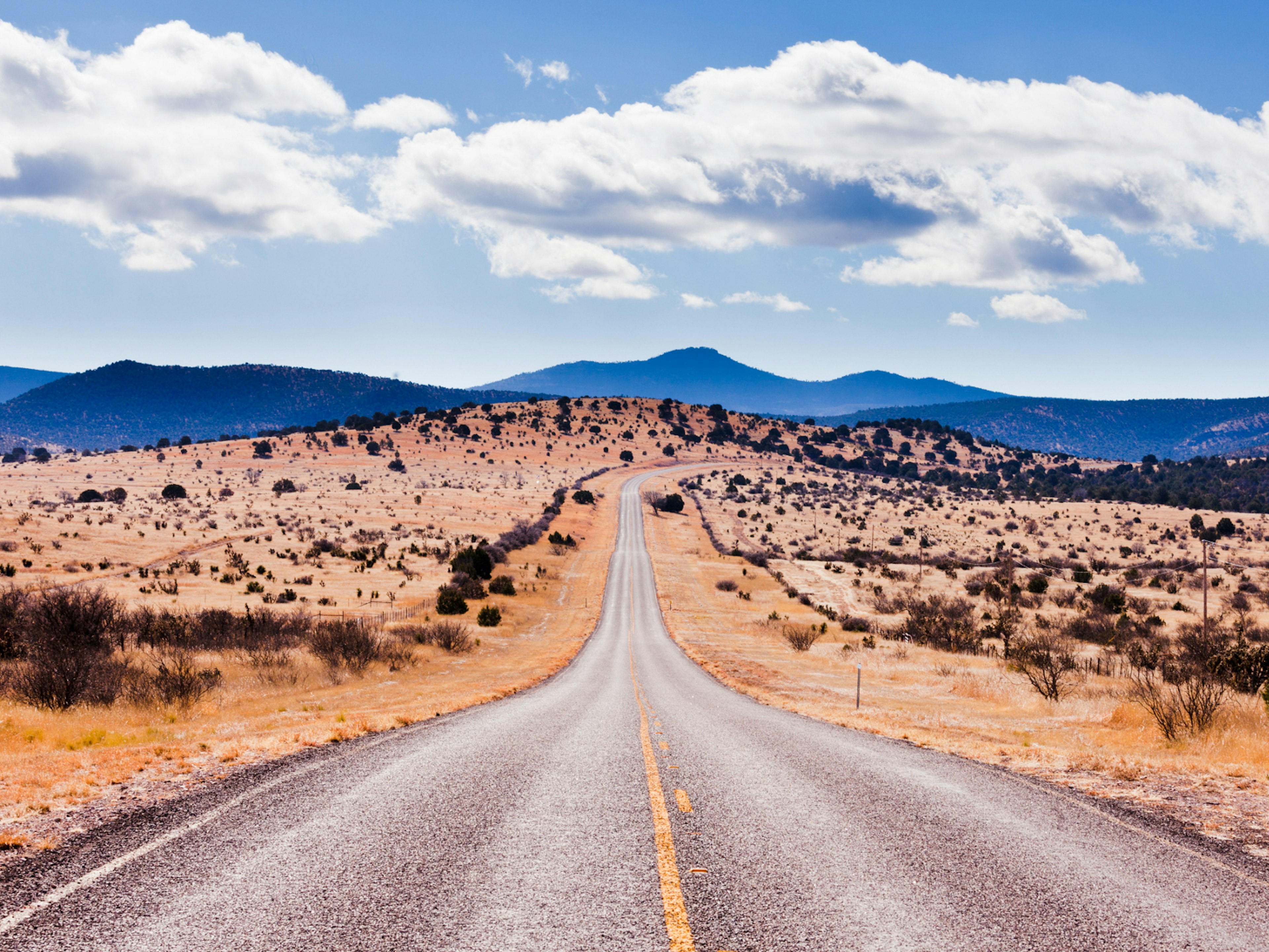 A straight road running through the desert landscape of Davis Moutains, Texas