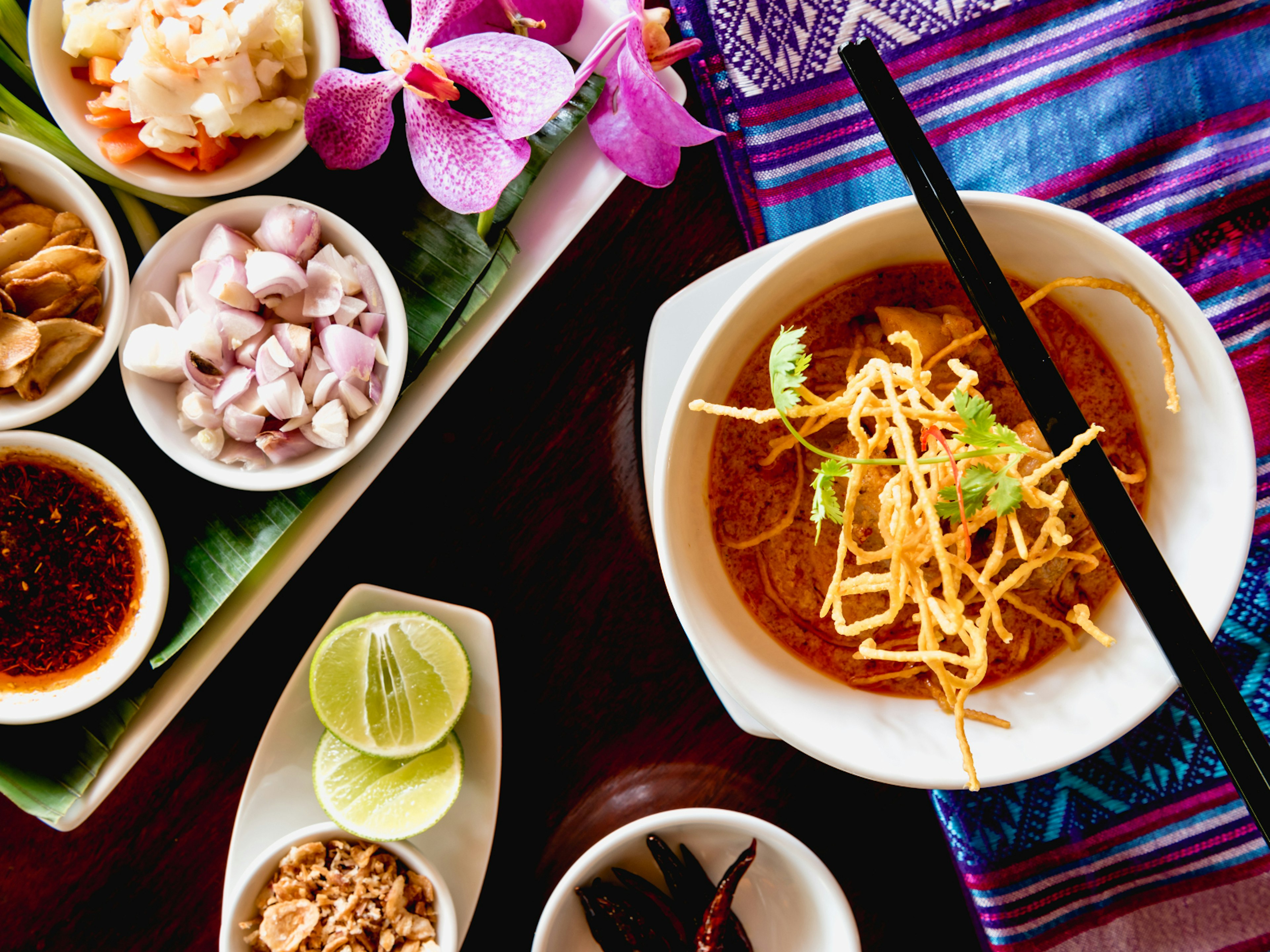 A bowl of khao soi on a decorative table