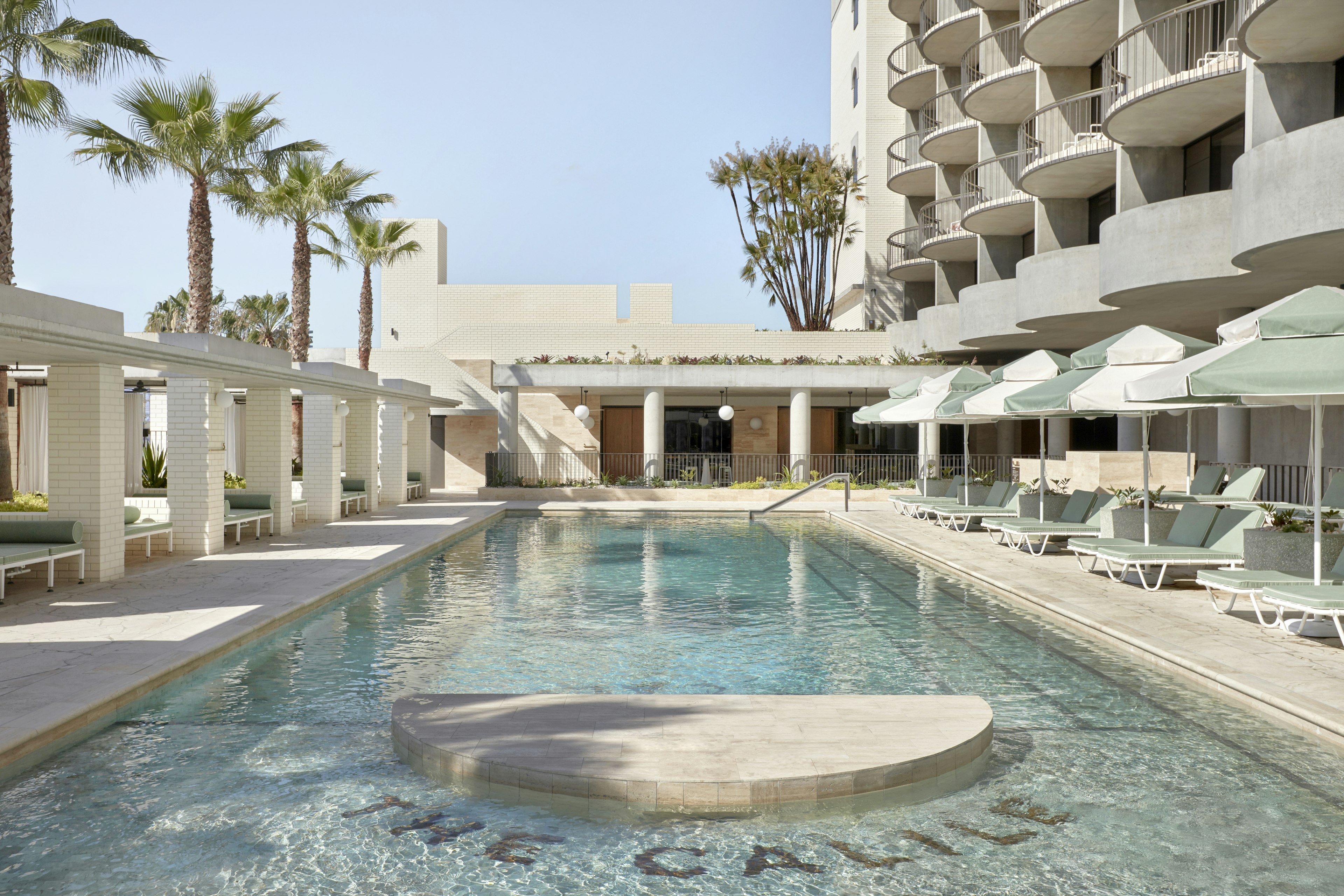 The Calile hotel logo tiled on the floor of its pool on a sunny day