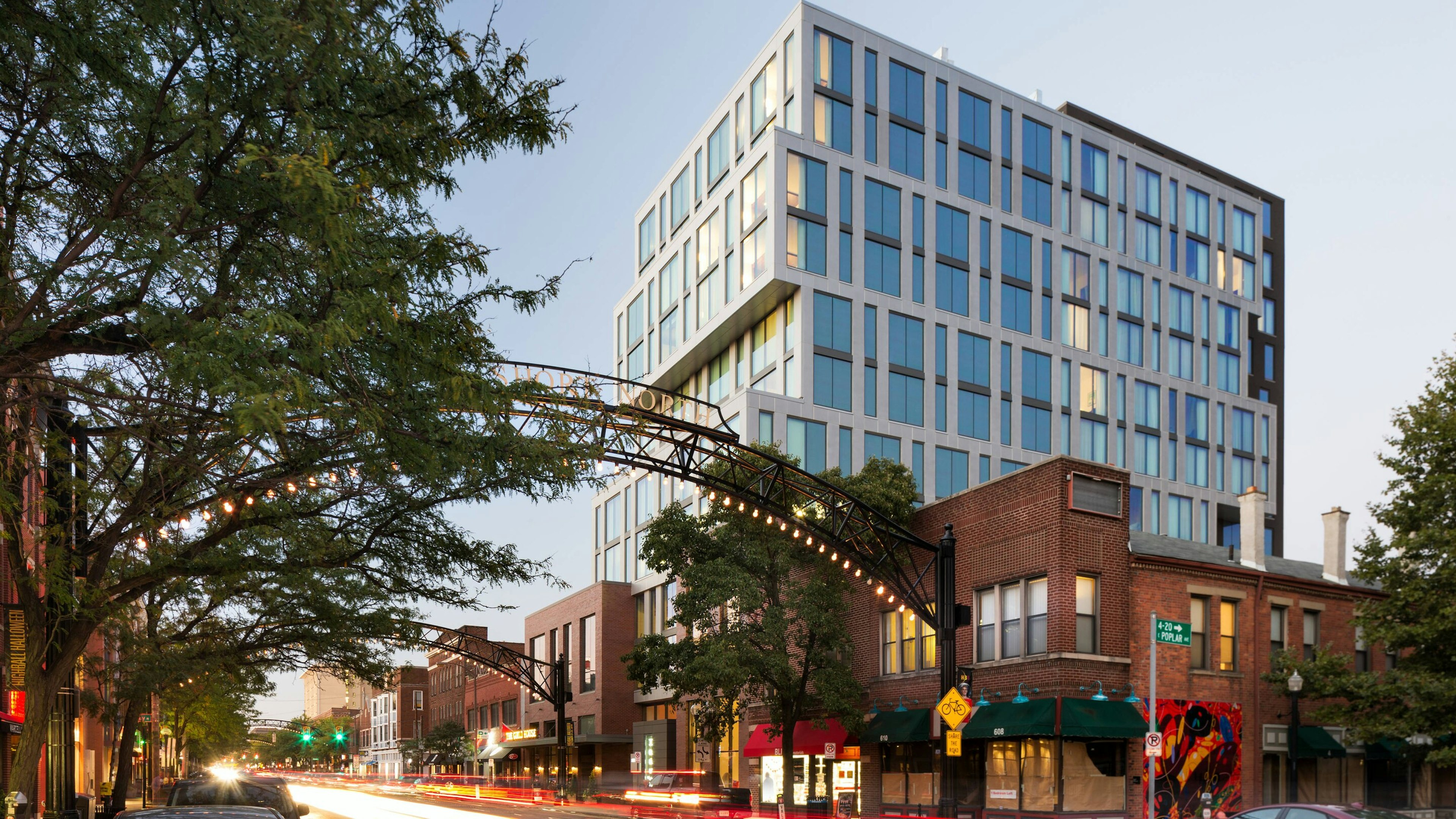 A pair of large metal archways sit in front of the Le Meridien Columbus, The Joseph Hotel. A blur of cars sped by as the sun sets; Columbus vs Ann Arbor