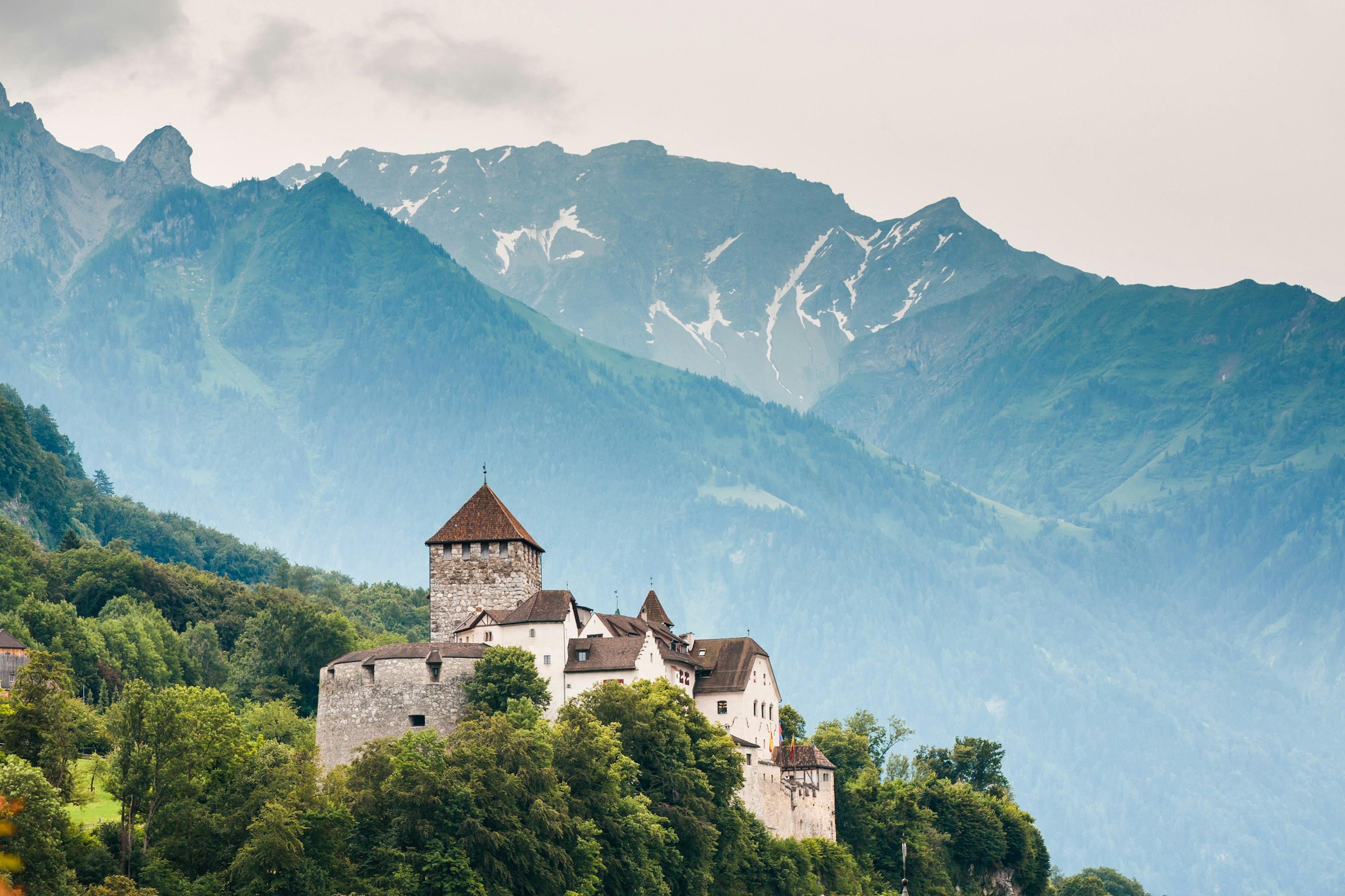 A view looking up to Vaduz castle and the towering Alps in the background