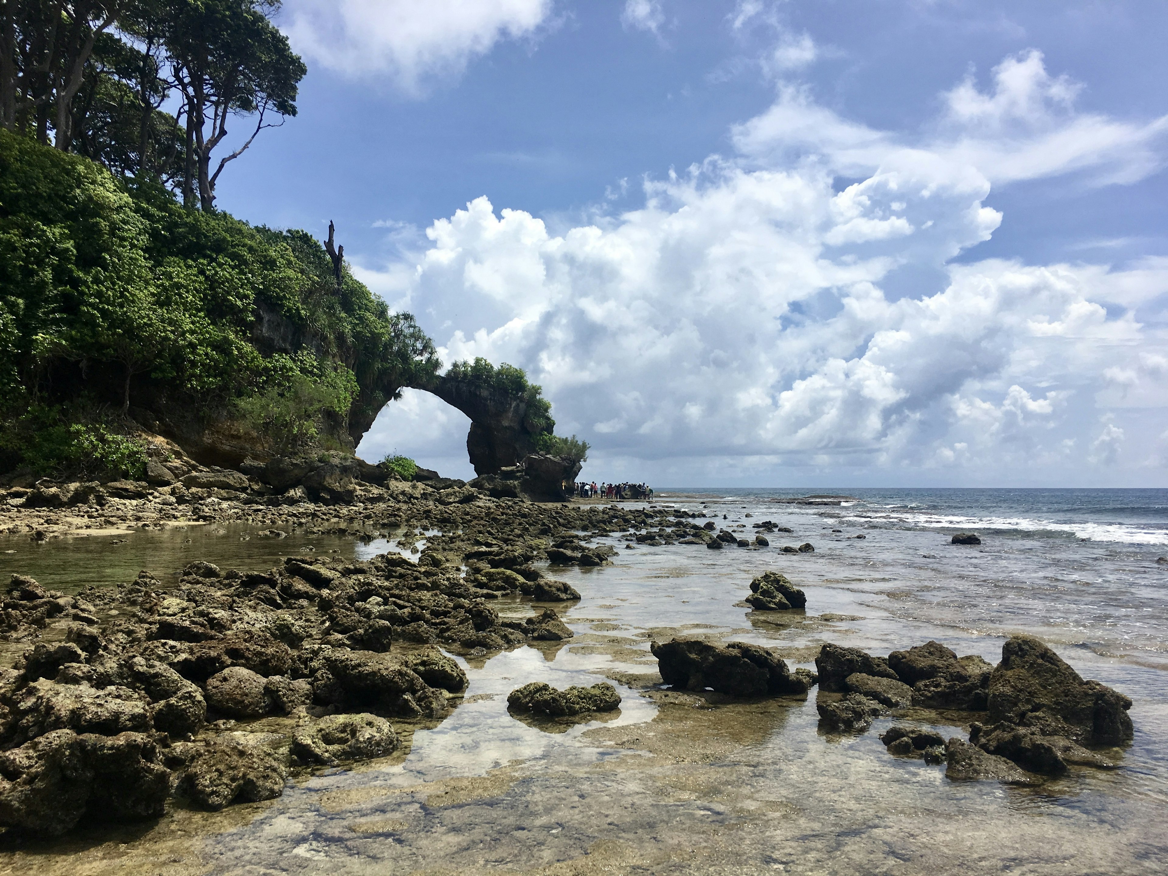 A view of a rock formation on the beach of Neil Island. The rock has been eroded to form a large arch, spanning a section of the rocky beach.