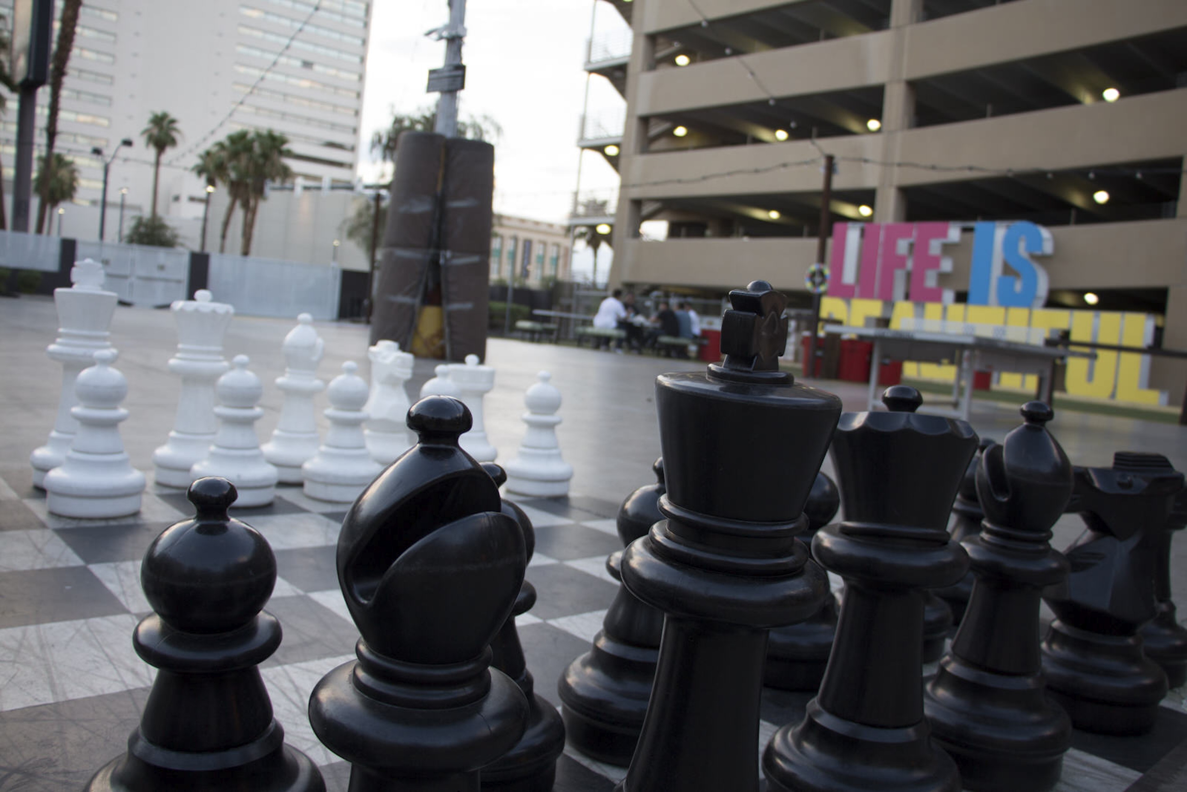 A large chess set, big enough for people to walk around and move the pieces, is seen in the foreground of an outdoor games area in Las Vegas © Greg Thilmont / Lonely Planet