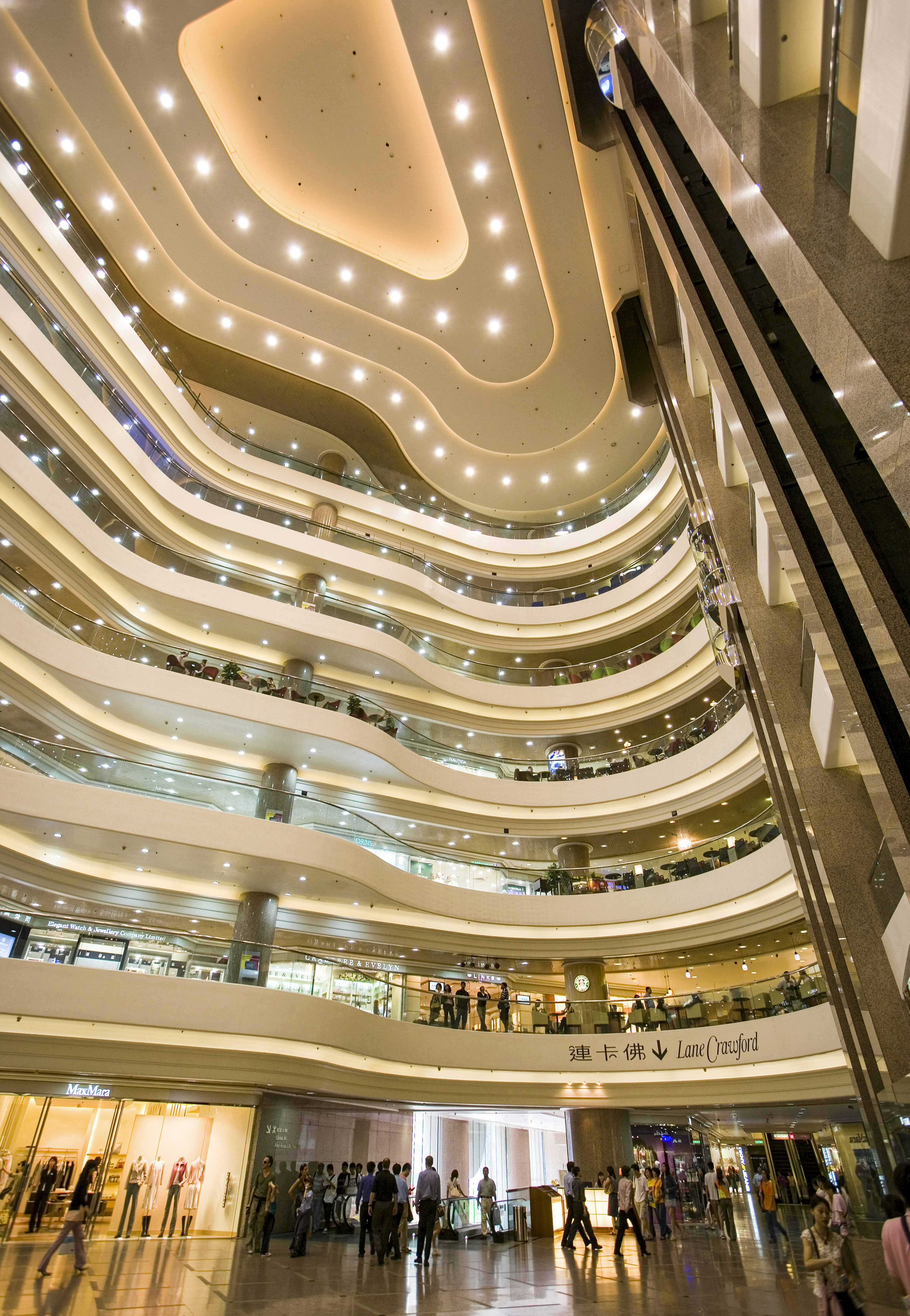 A view of a well-lit, tiered atrium with seven stories at Times Square Mall, Hong Kong.