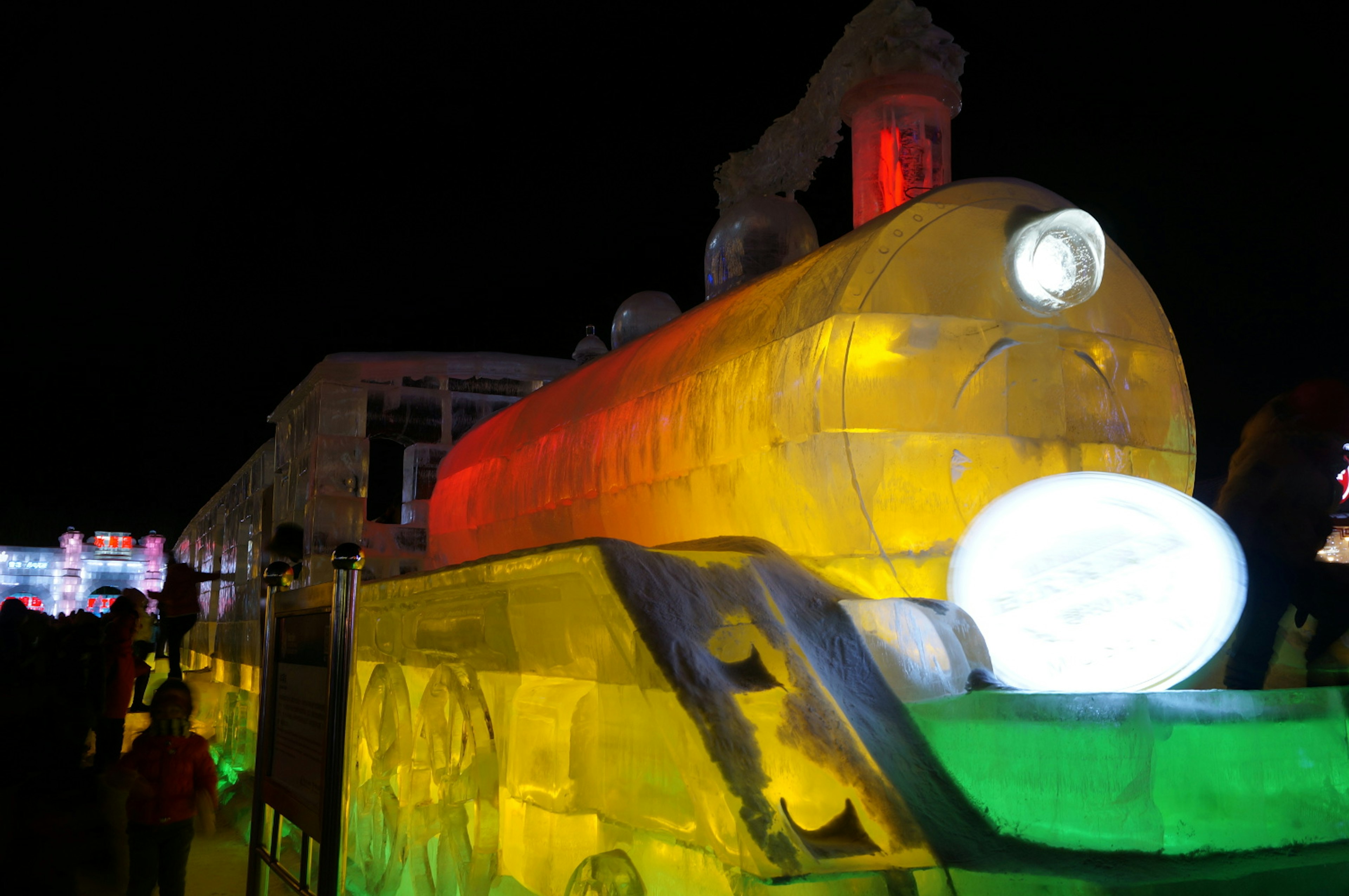 An icy train sculpture that is almost to full scale glows with colours and nods to Harbin's long railway history