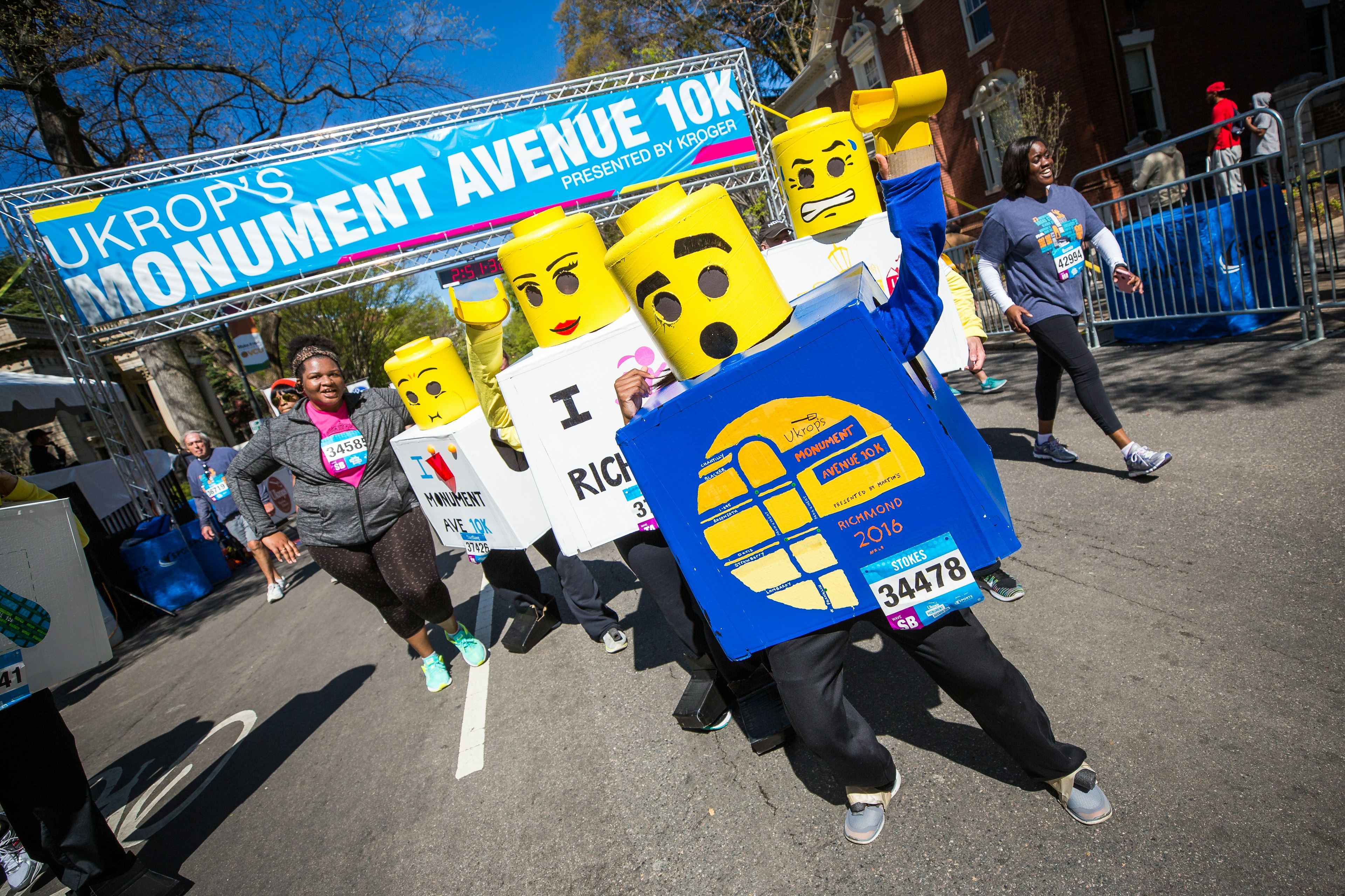 A group of people dressed as legos cross the finish line of a 10K race