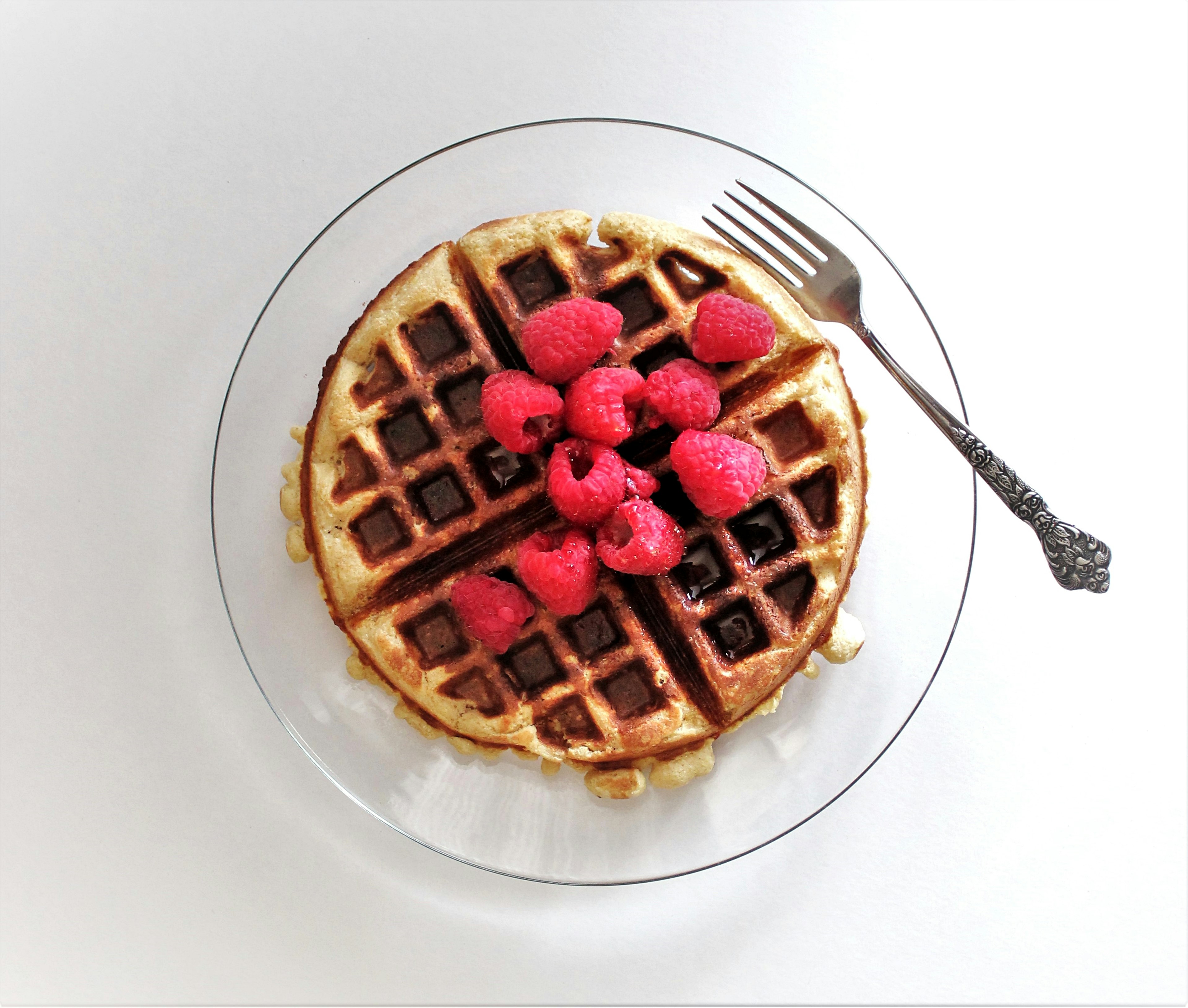 Plate with a vegan waffle, organic raspberries and syrup; Seattle vegan restaurants