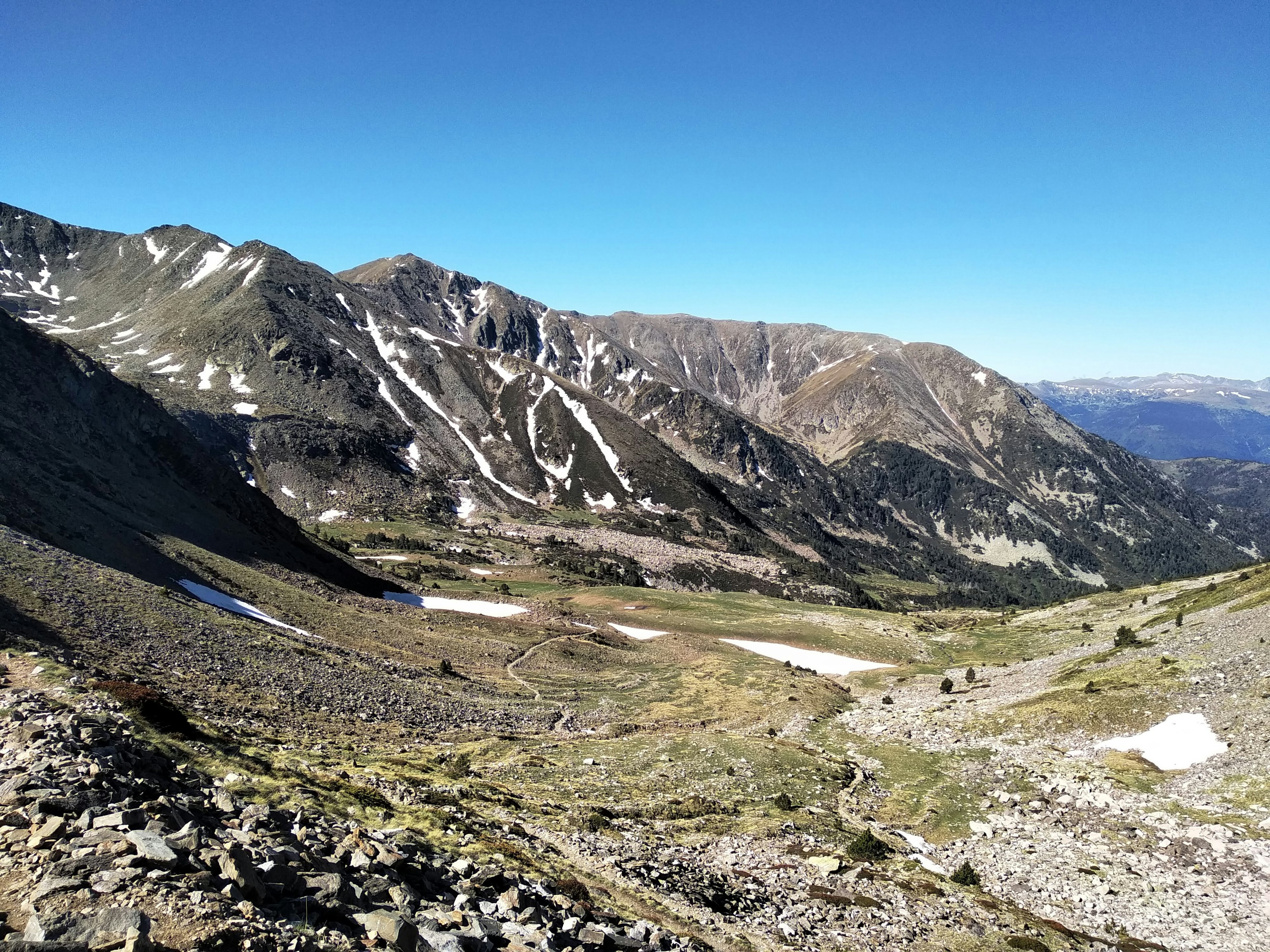 The view climbing up Canigou, of a barren valley surrounded by mountains.