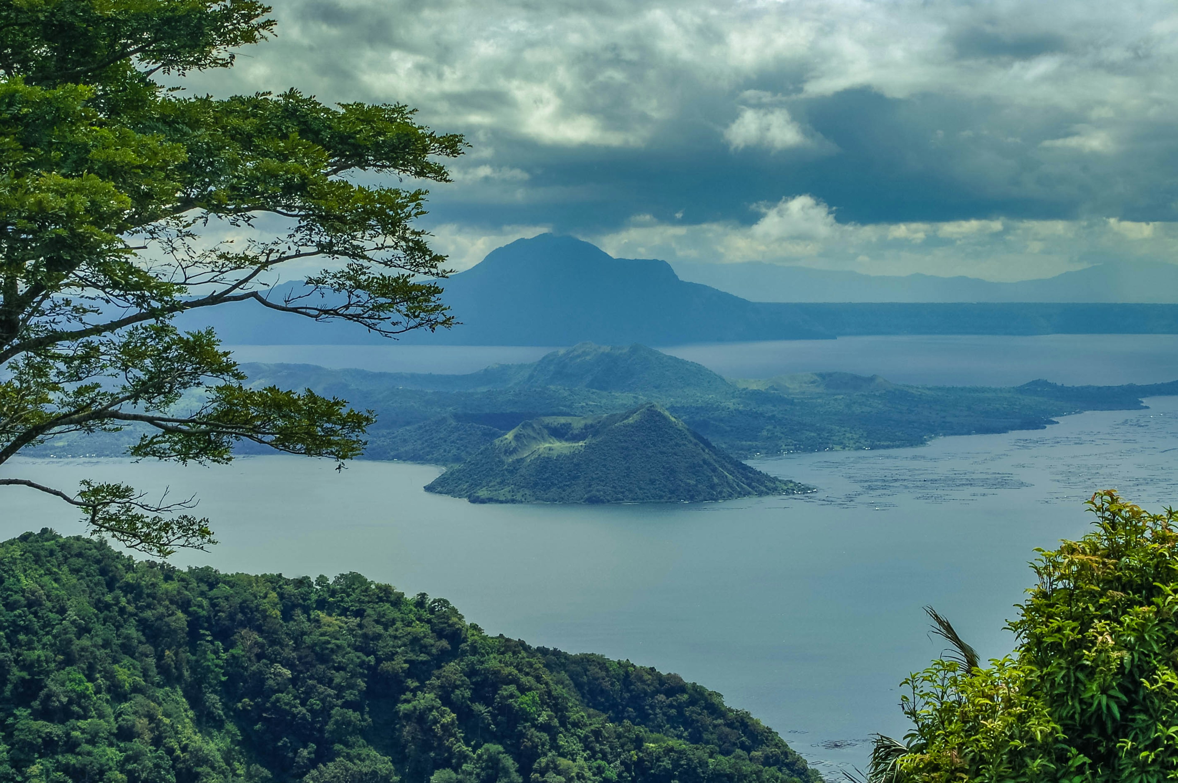 717276811
Mountain Range, Mountain Peak, Landscape, Nature, Outdoors, Smoke - Physical Structure, Day, Beauty In Nature, No People, Sky, Volcano, Mountain, Cloud - Sky, Scenics, Travel Destinations, Volcanic Landscape, Tranquility, Tree, Philippines, Taal, Horizontal Image