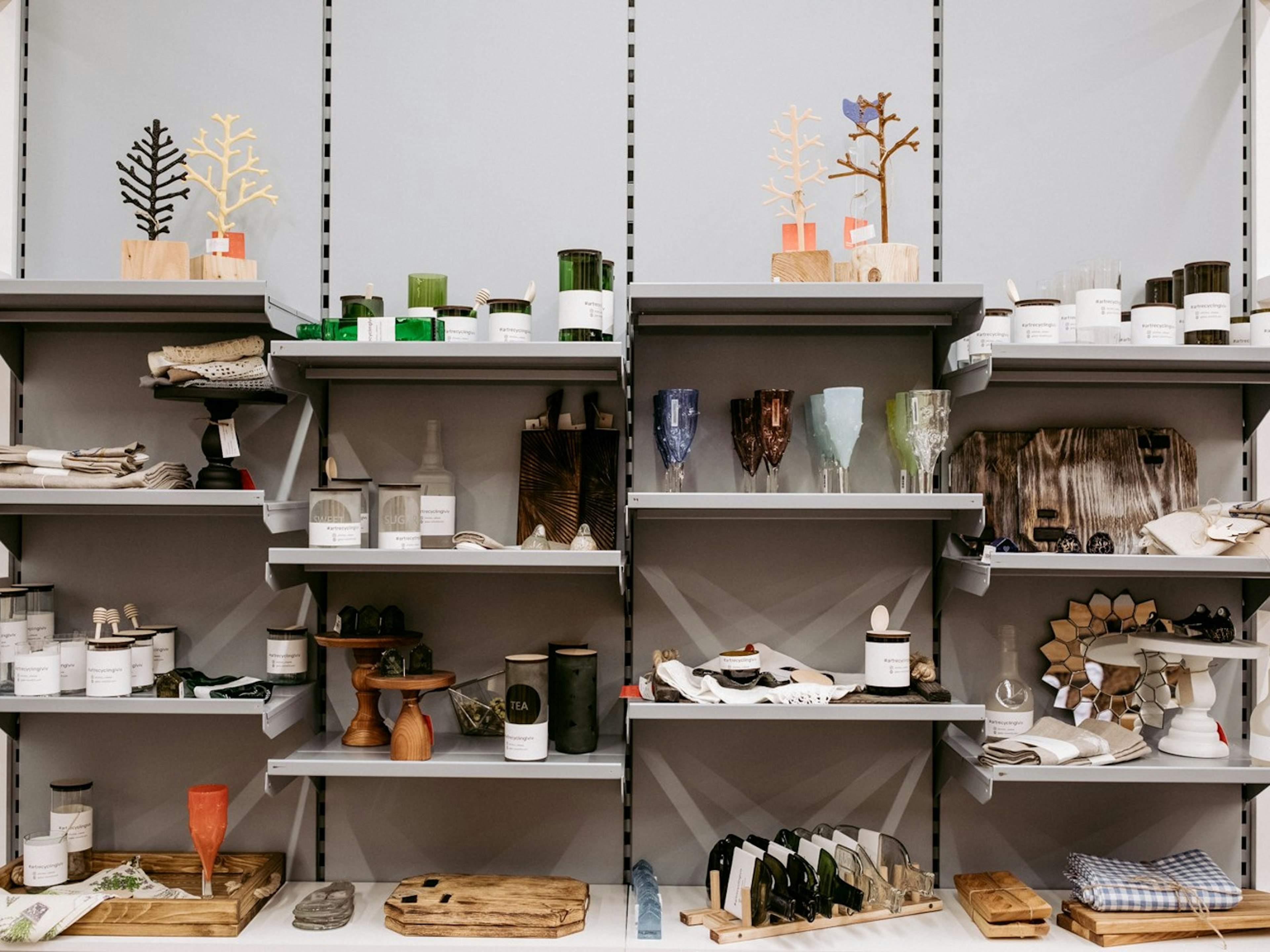 Interior shot of a home store in Ukraine, with shelves full of candles, goblets and carved wooden items such as candlesticks.