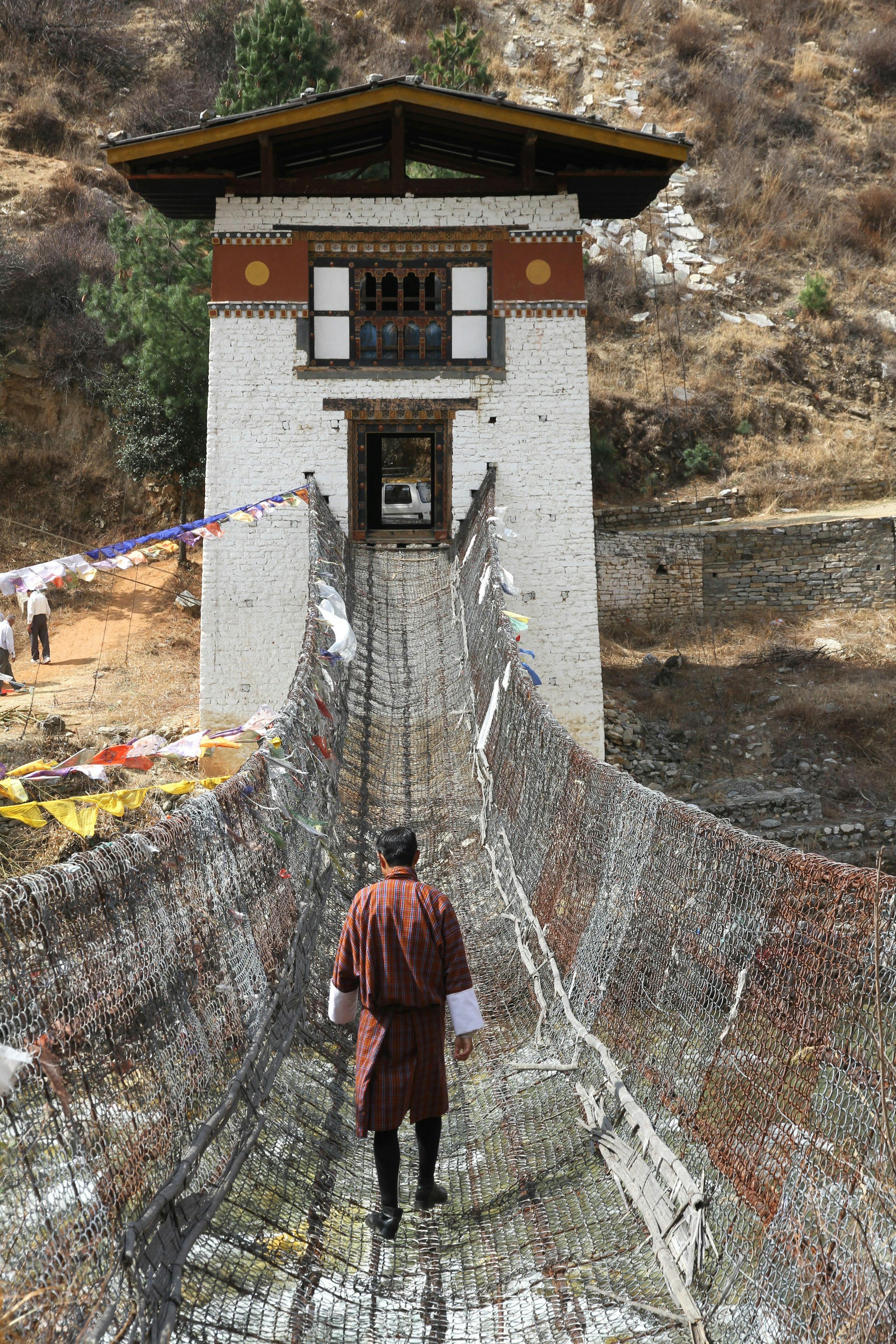 Walking gingerly across the traditional iron link bridge at Tamchog Lhakhang © Bradley Mayhew / Lonely Planet