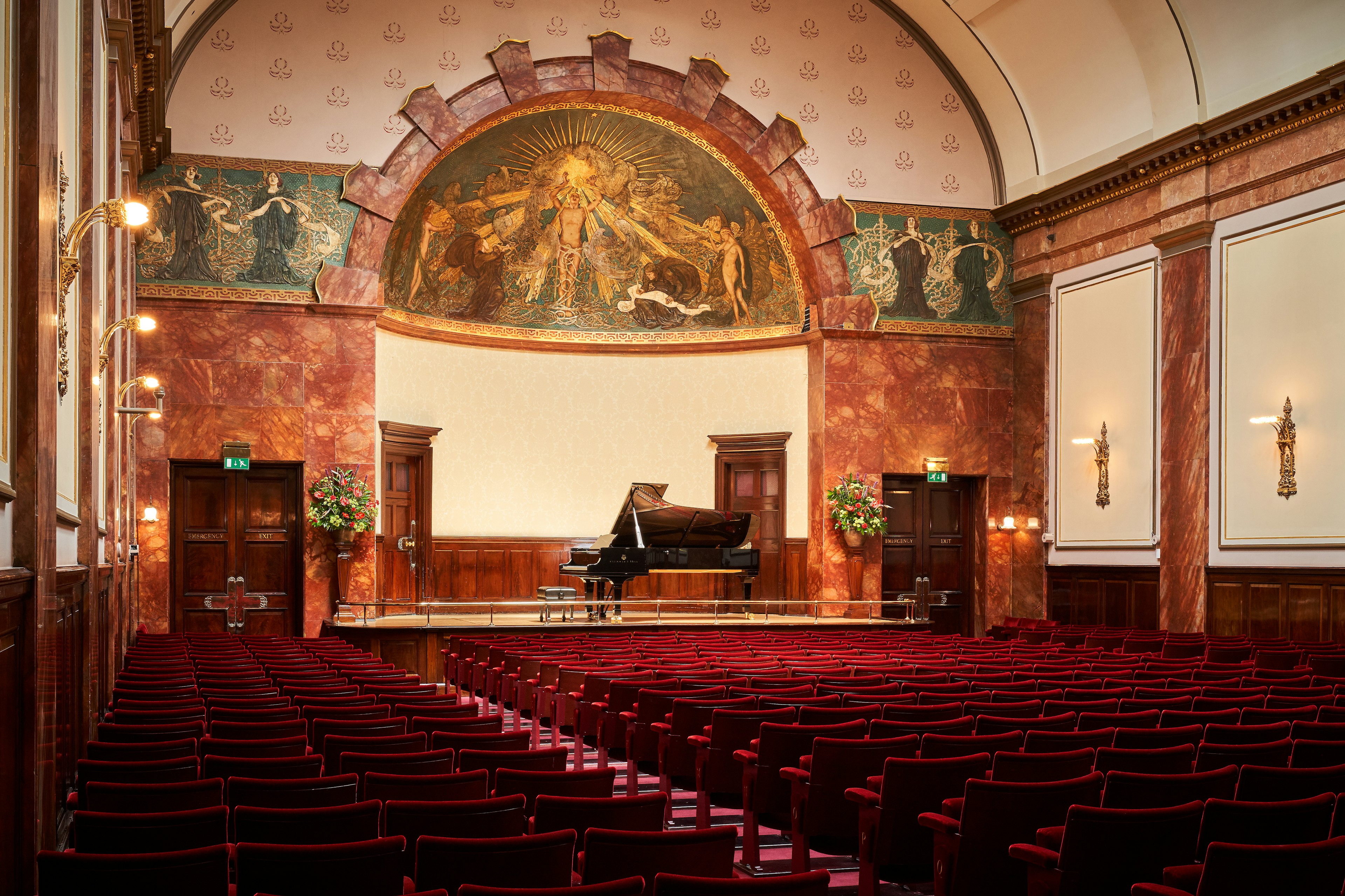 The grand interior of Wigmore Hall in London, with religious iconography behind the stage.